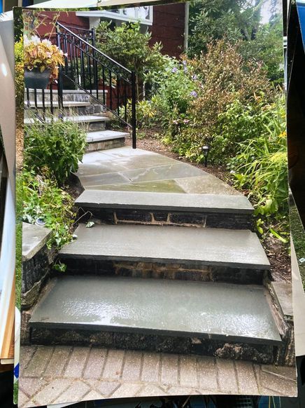 Concrete steps with dark stone risers leading to a stone walkway and garden stairs in a residential yard. Concrete steps with dark stone risers leading to a stone walkway and garden stairs in a residential yard.