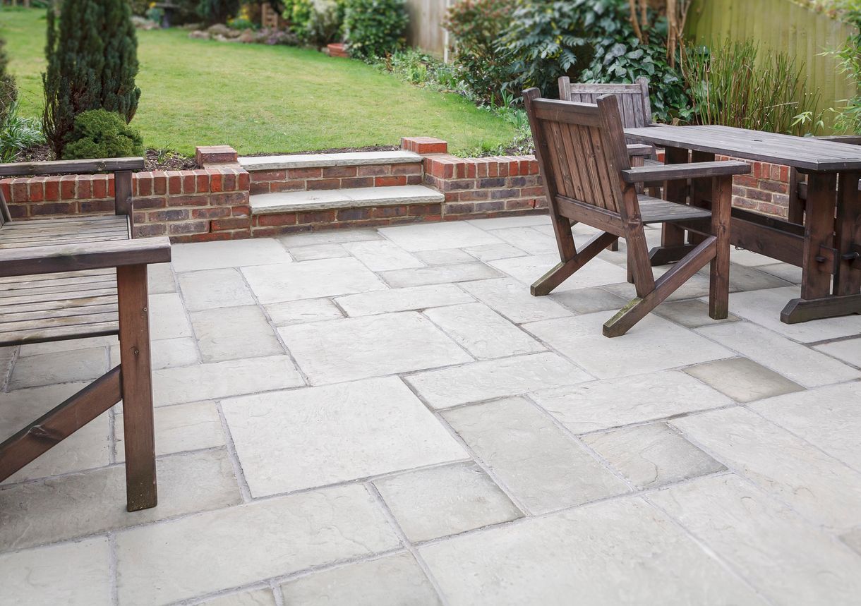 a patio with a table and chairs in a garden .