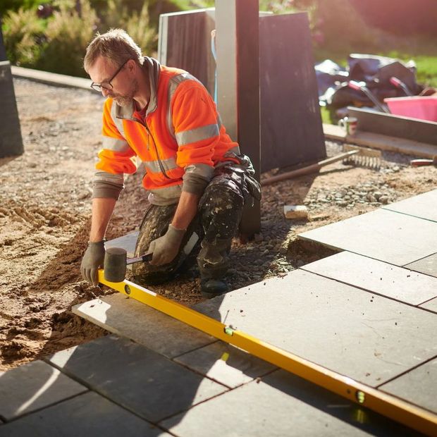 a man is measuring a tile floor with a tape measure