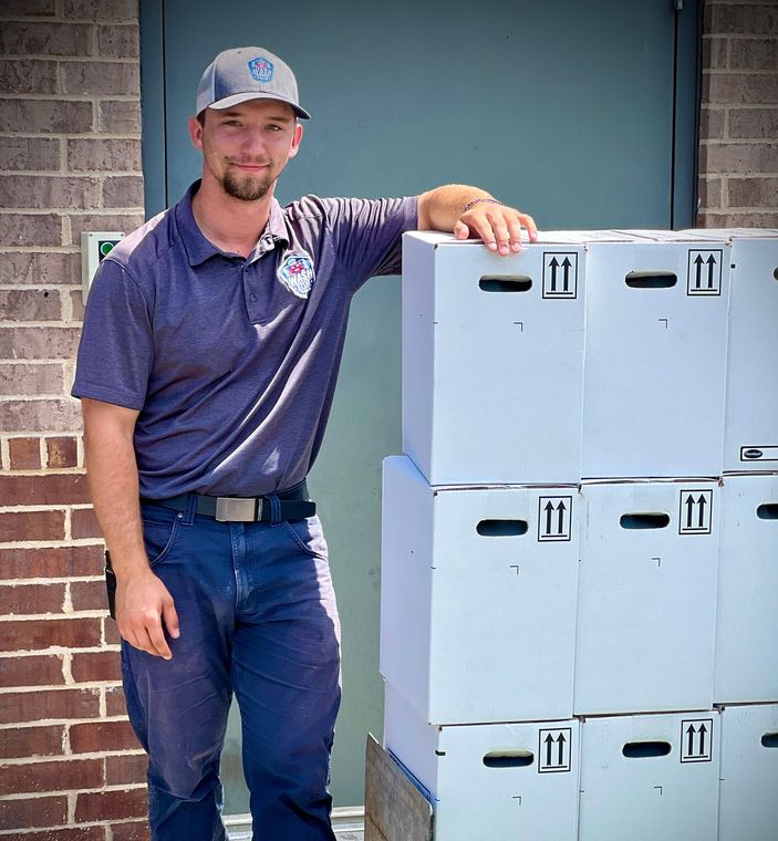 a wash associates staff member is standing next to a cart full of boxes