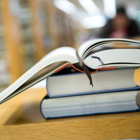 Three piled books with topmost open