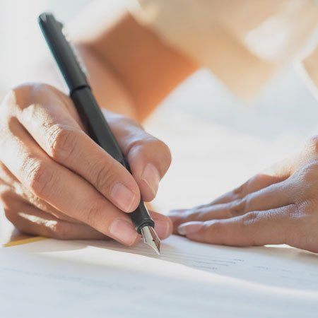 Mixed Race boy writing at school desk