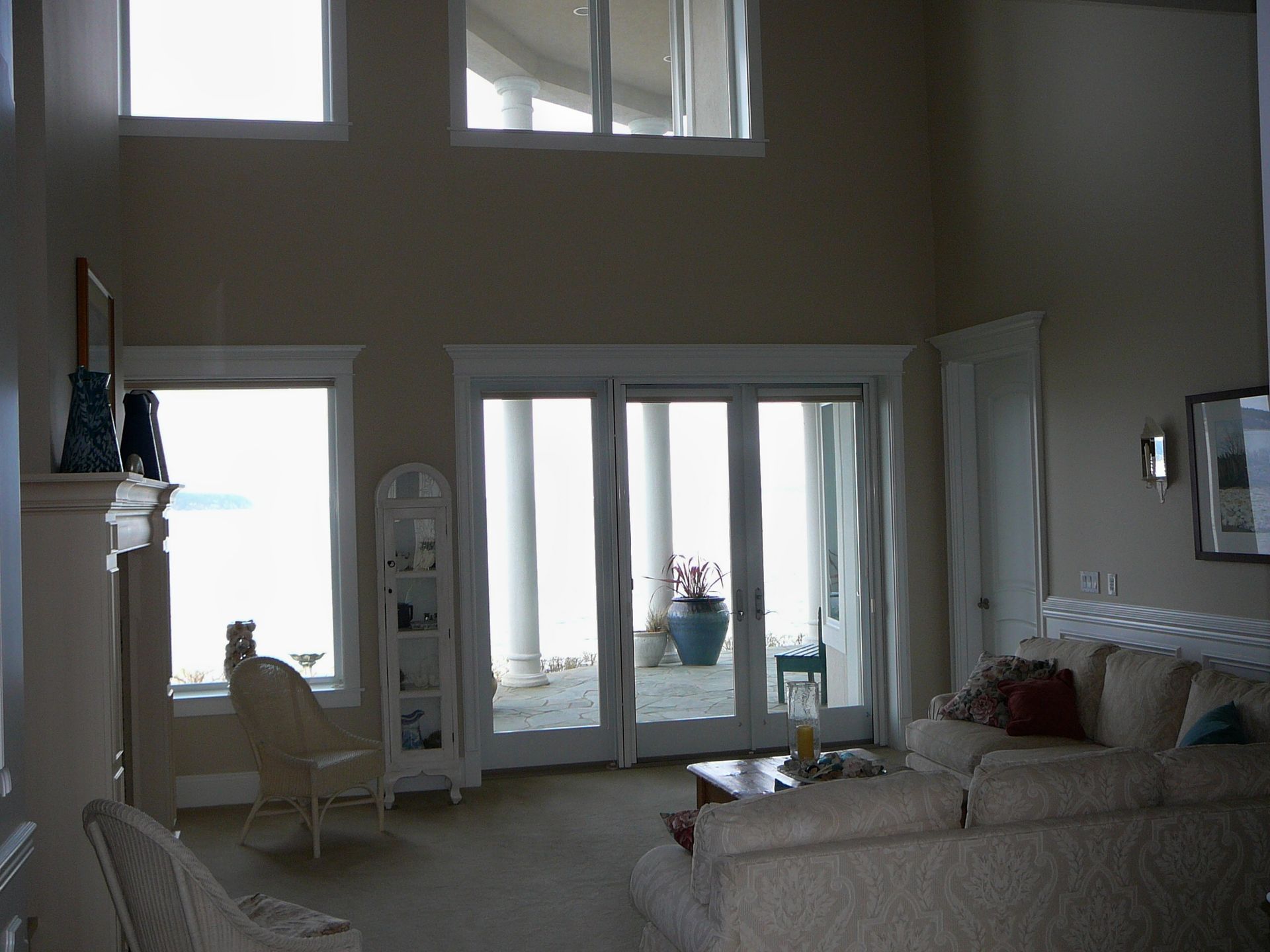 A living room with a lot of windows and sliding glass doors