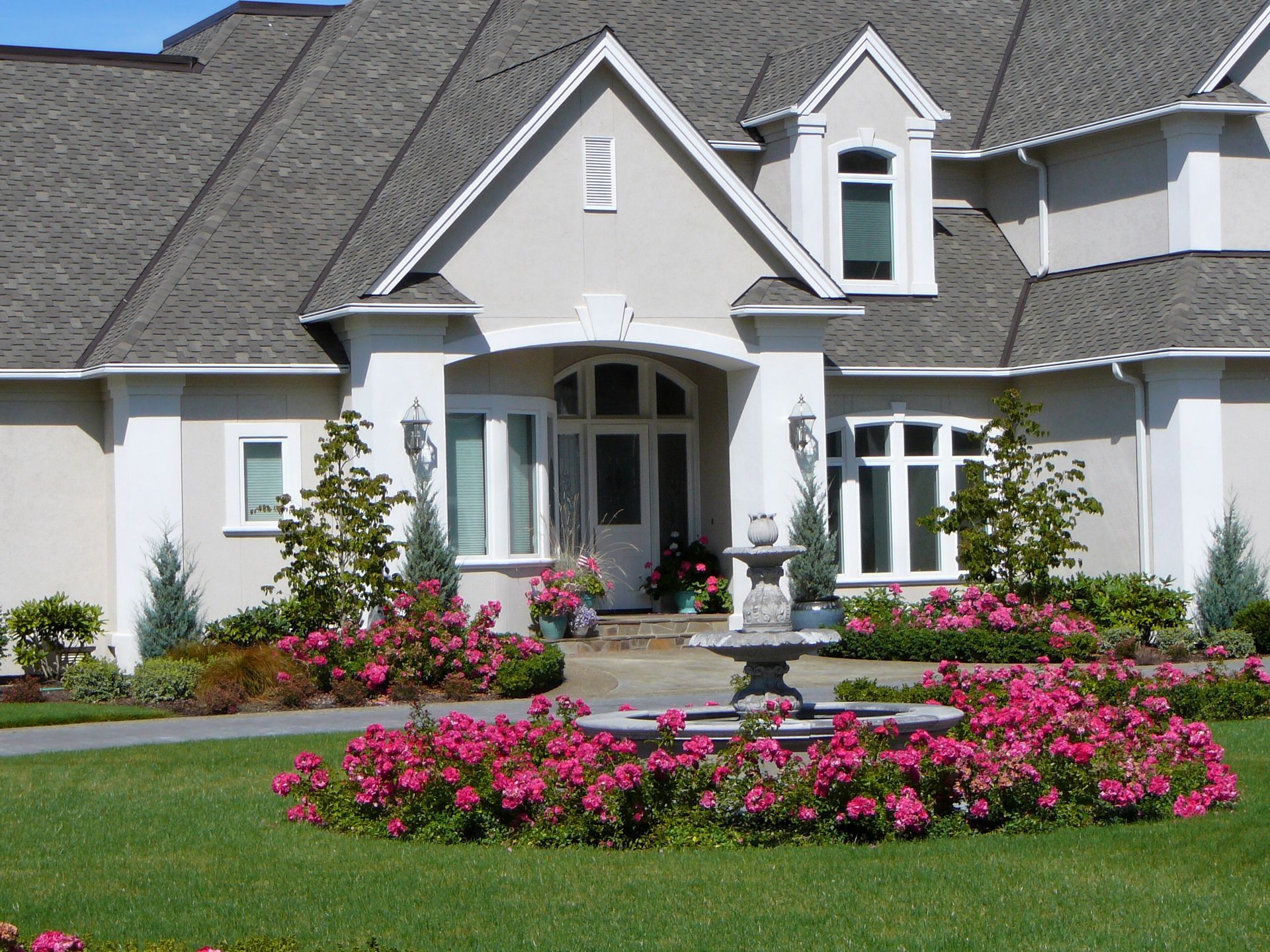 A large house with pink flowers in front of it