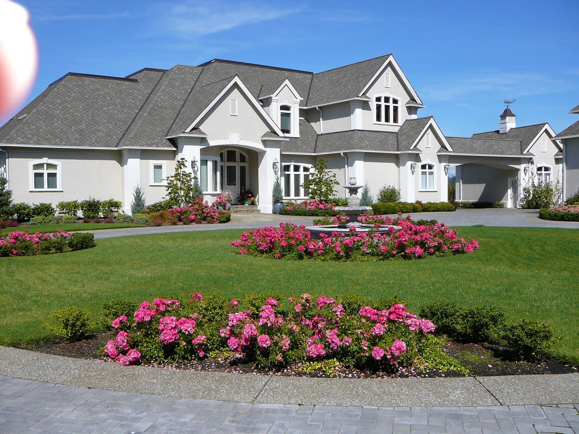 A large house with pink flowers in front of it
