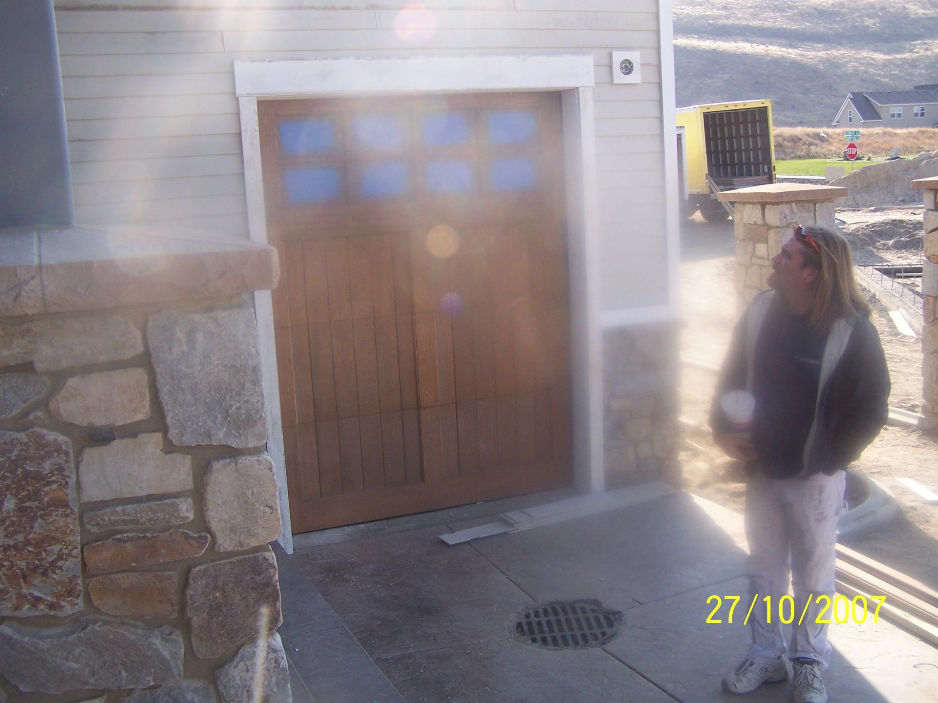 A woman is standing in front of a garage door on 27/10/2009