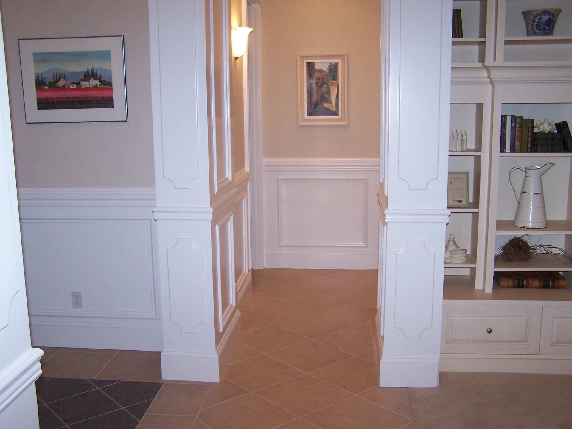 A hallway with white trim and a picture on the wall