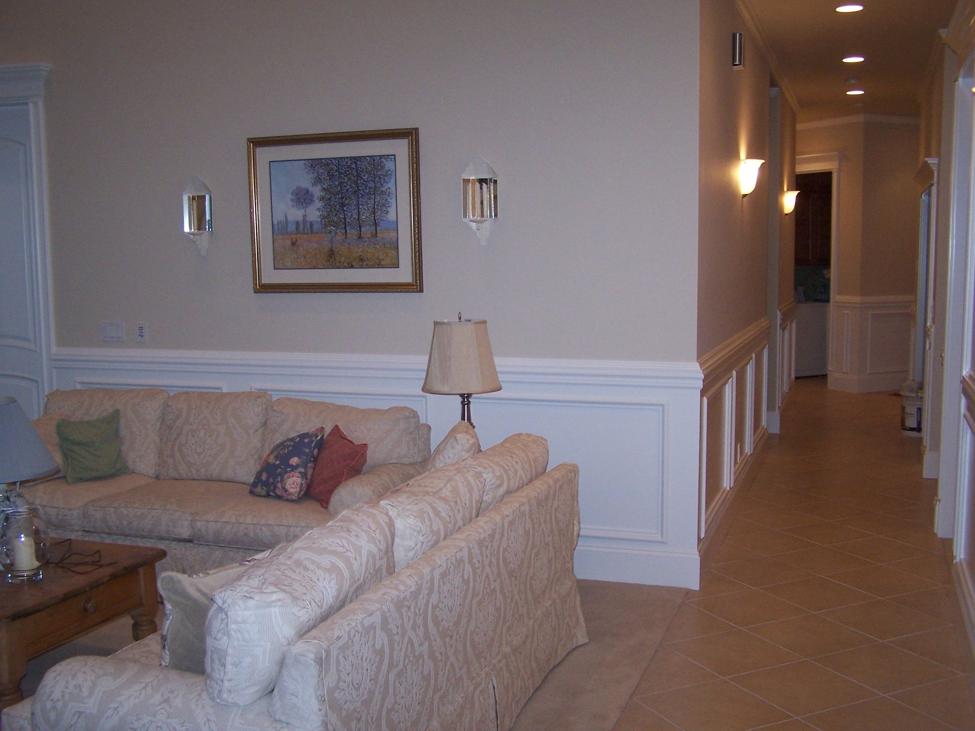A living room with a couch and a picture on the wall