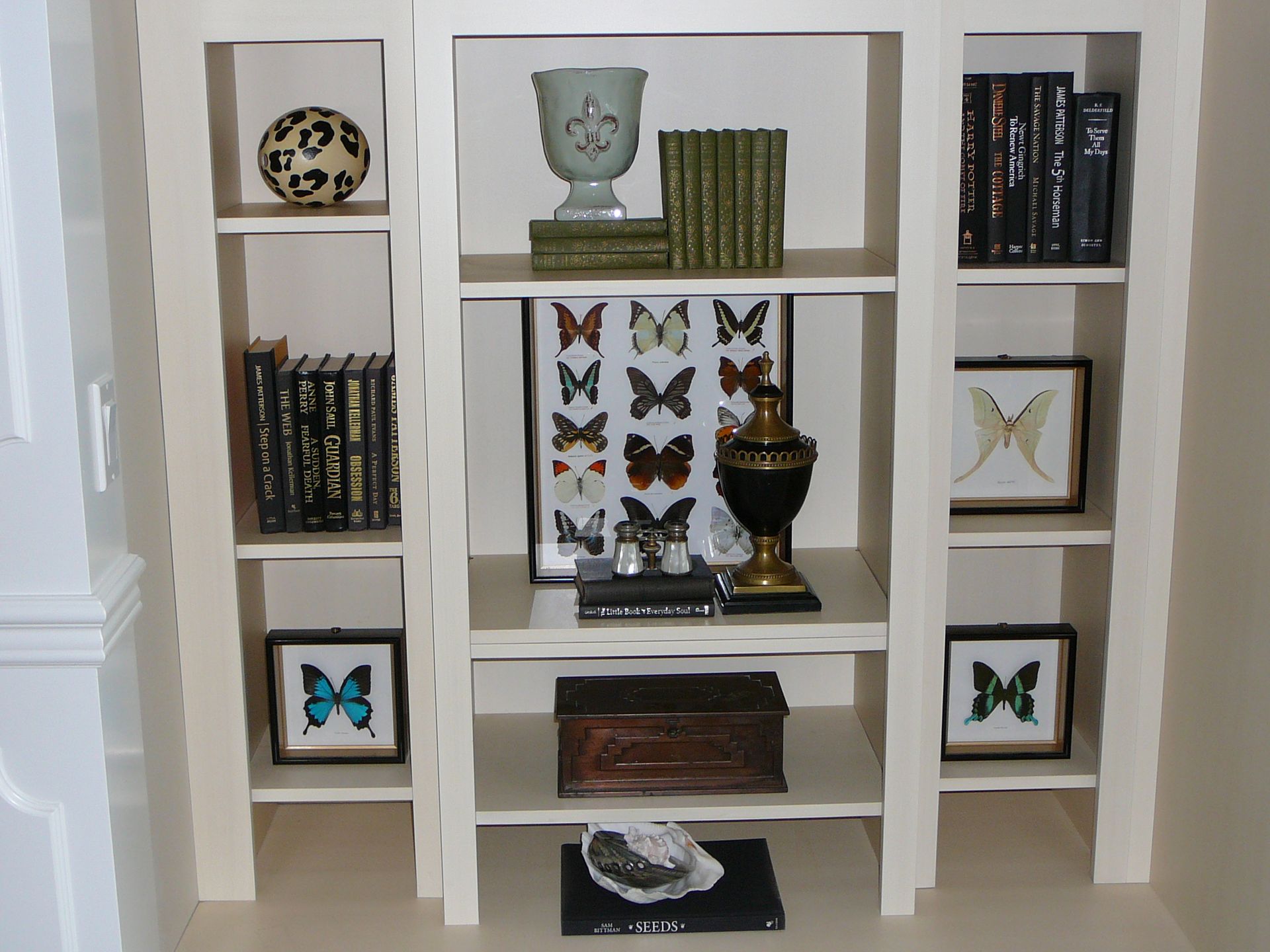 A bookshelf with a display of butterflies on it