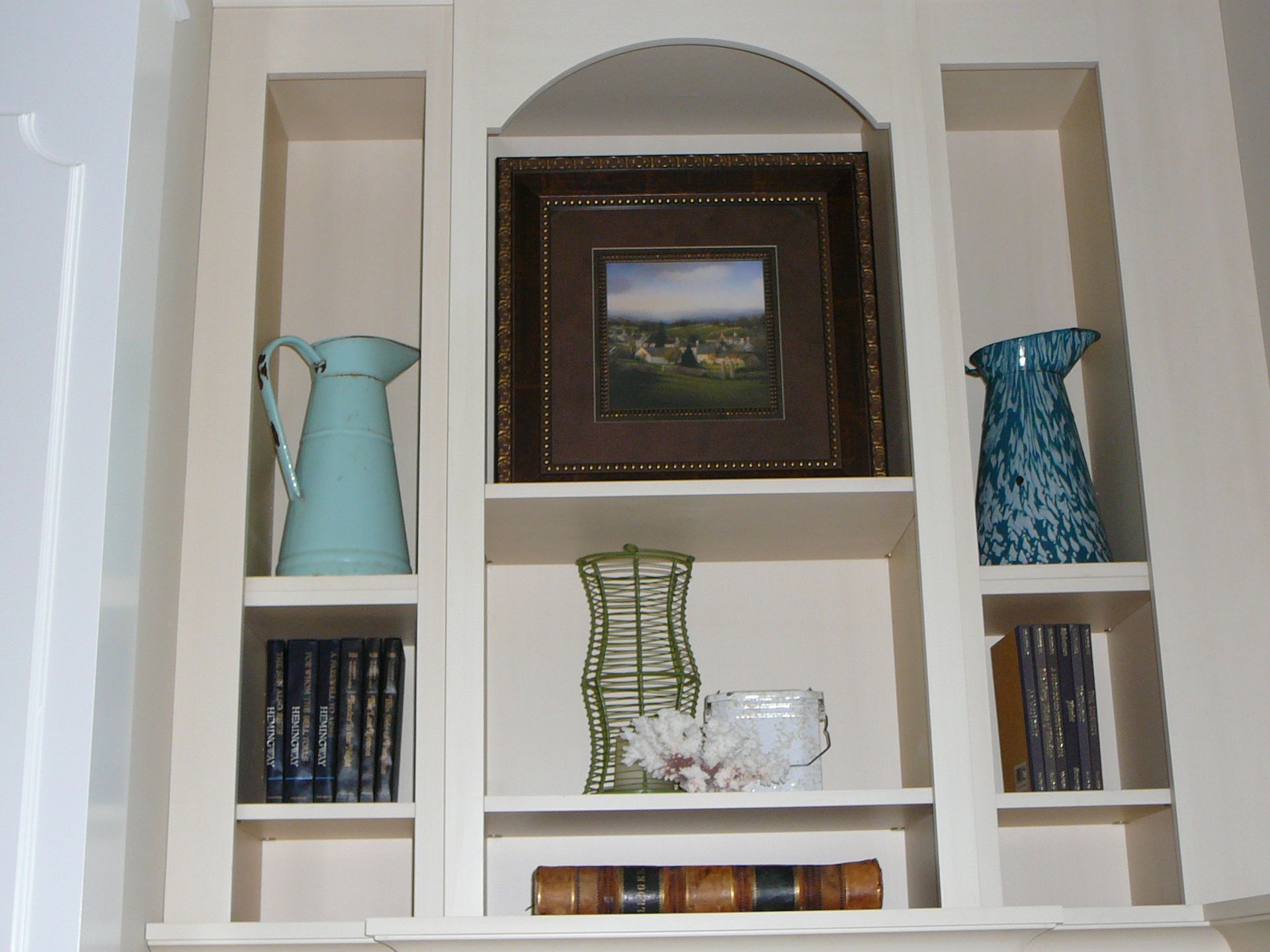 A shelf with a picture and vases on it