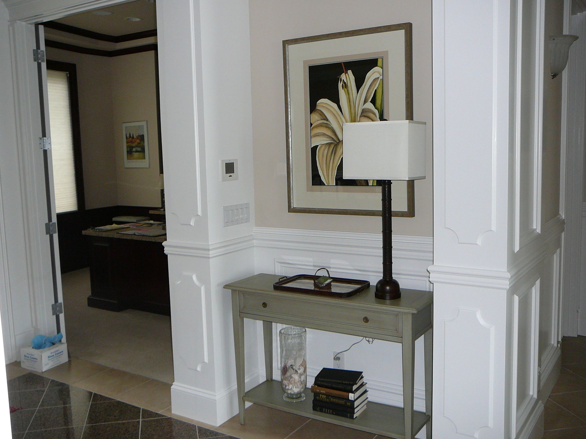 A hallway with a table and a lamp and a picture on the wall