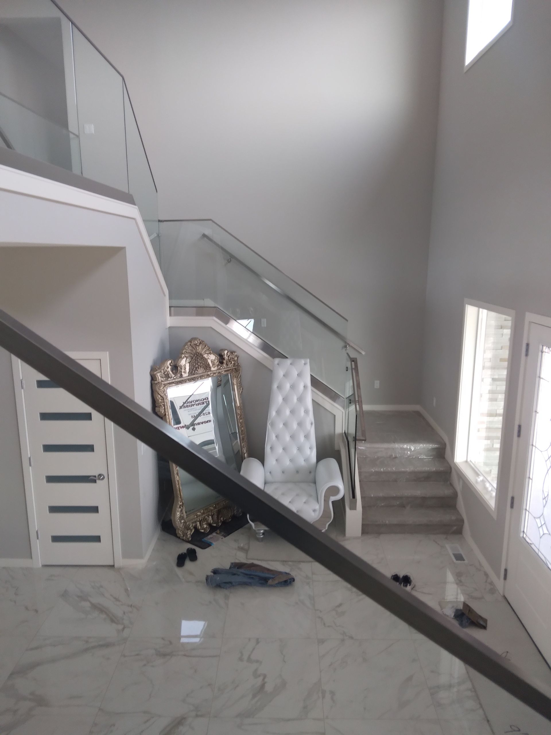 A staircase in a house with a chair and a mirror