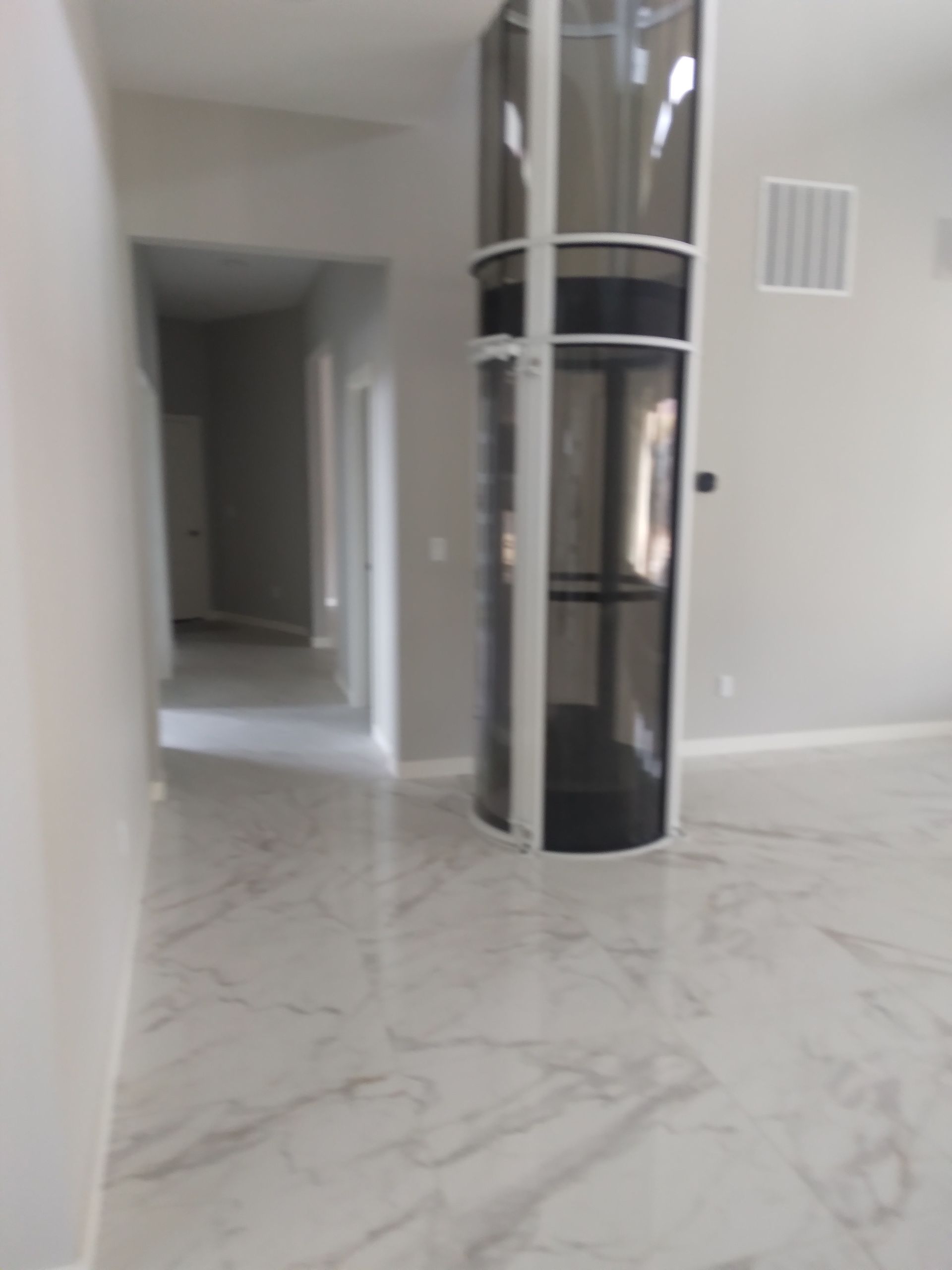 A room with a glass elevator in the middle of it