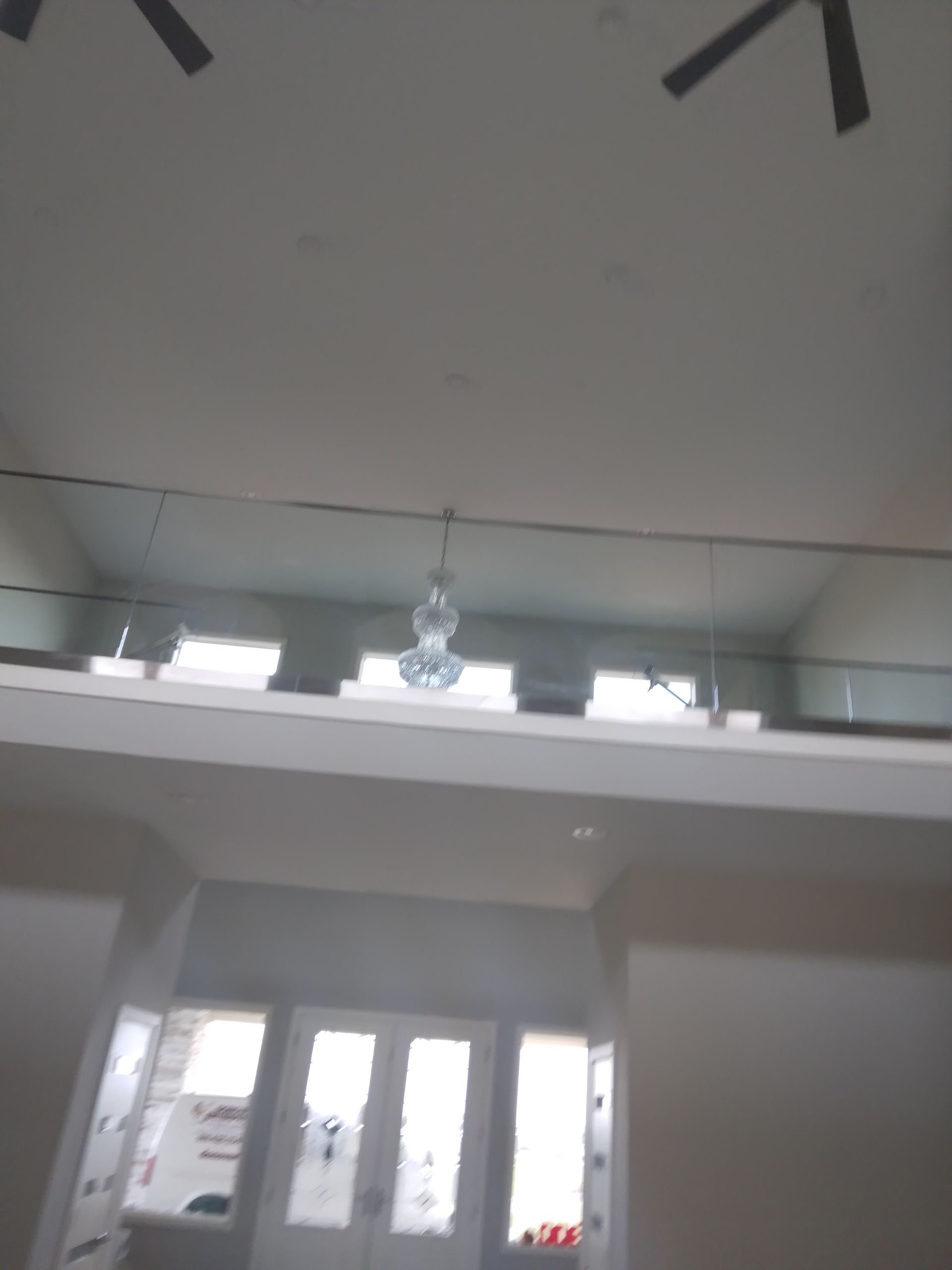 A room with a balcony and a ceiling fan