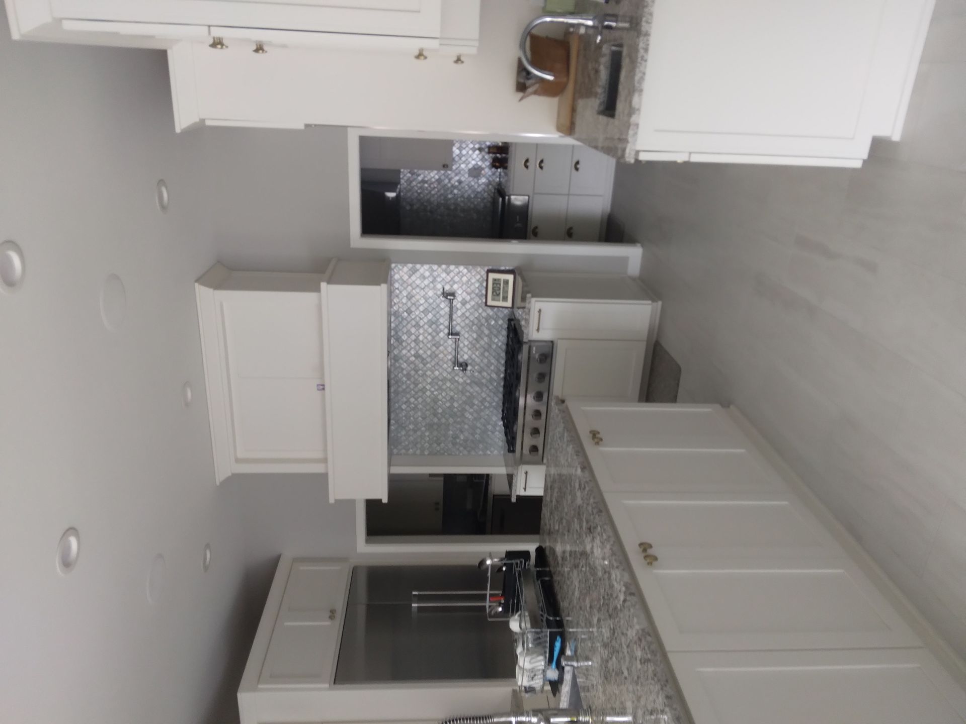 A kitchen with white cabinets and granite counter tops