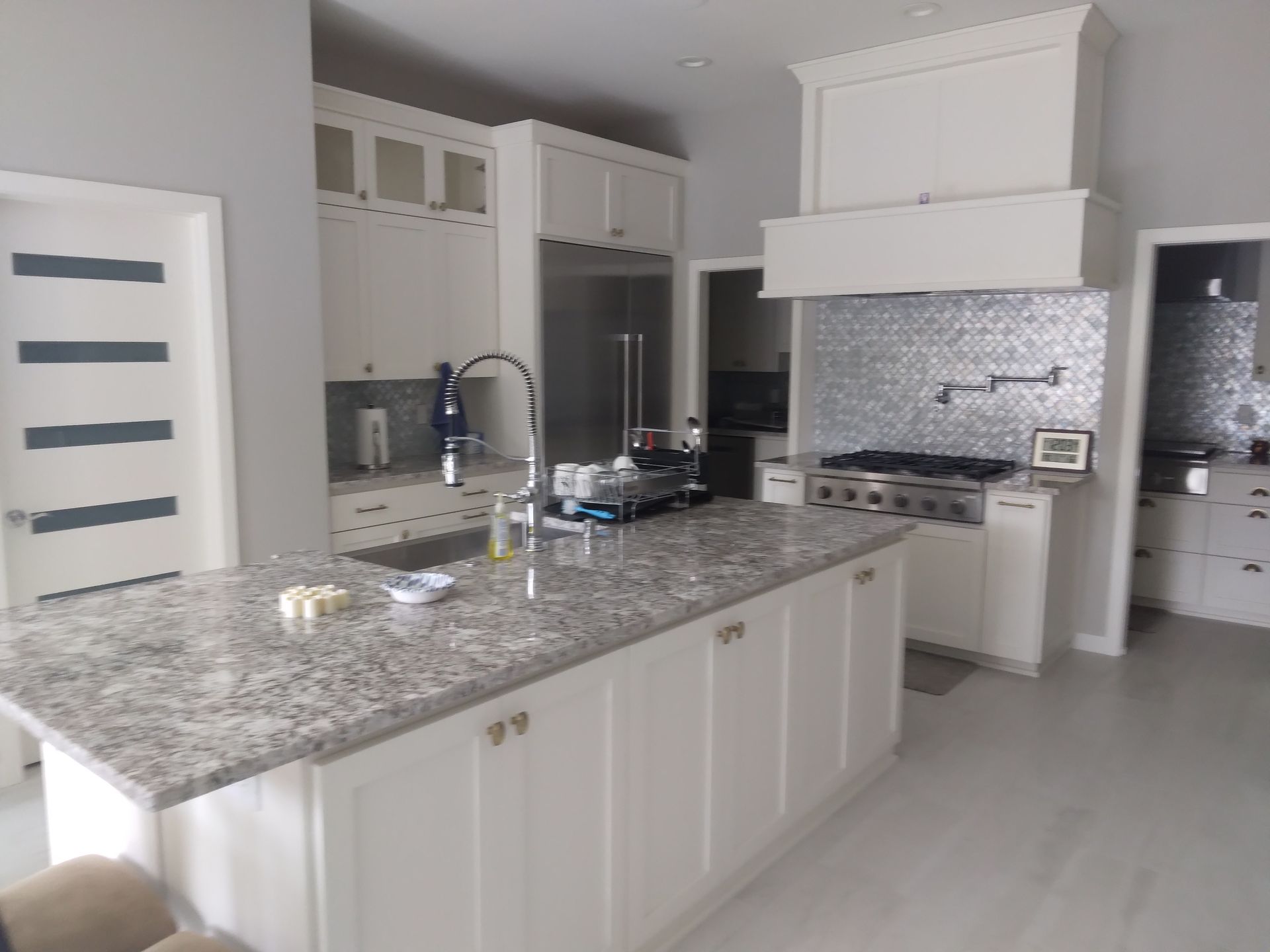A kitchen with granite counter tops and white cabinets