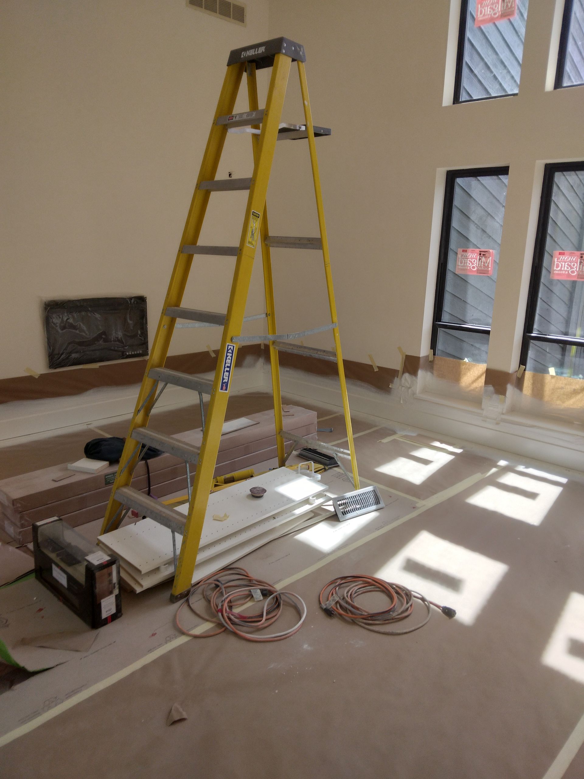 A yellow ladder is sitting on the floor in a room