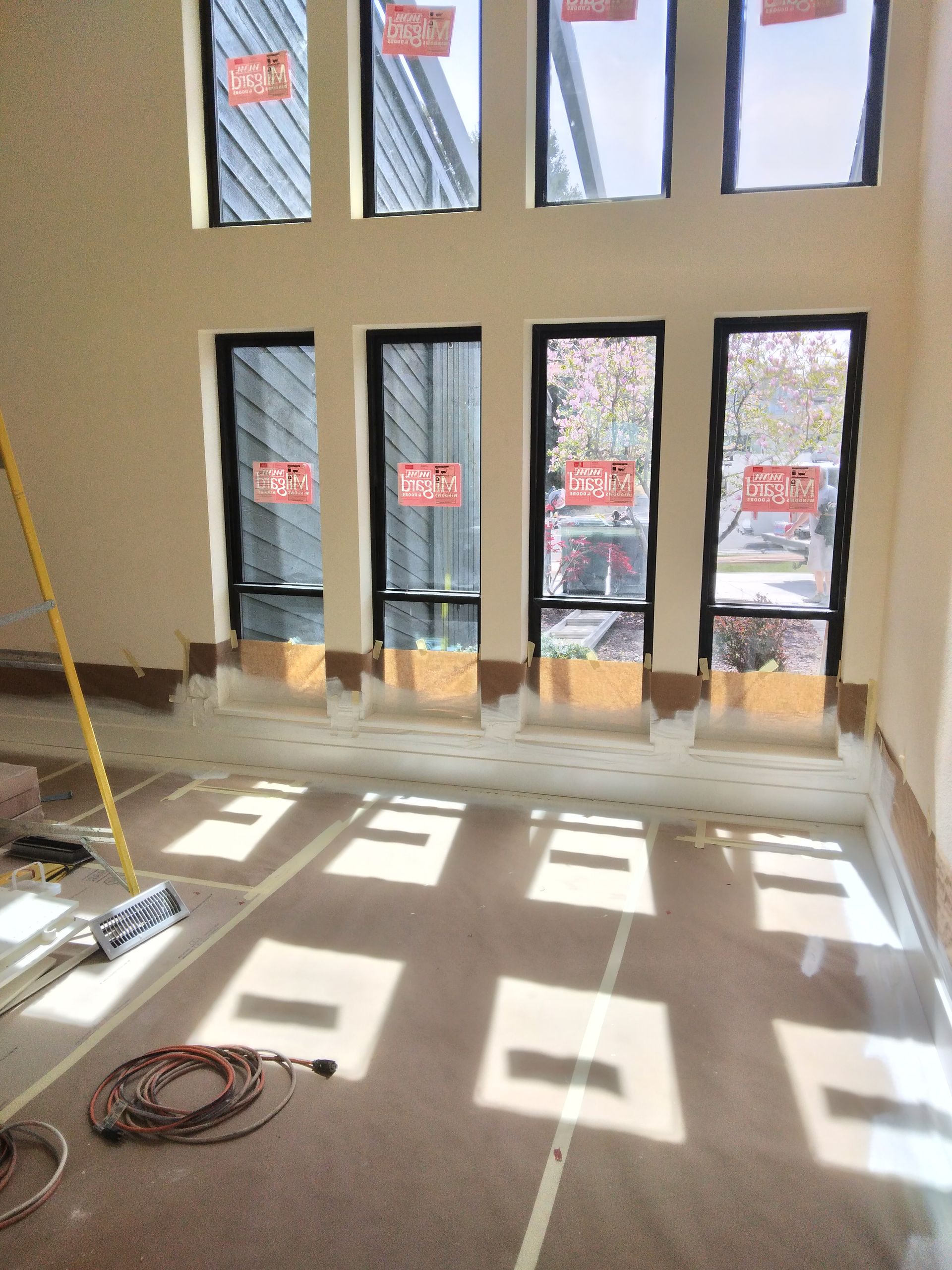 A room with a lot of windows and a mop on the floor