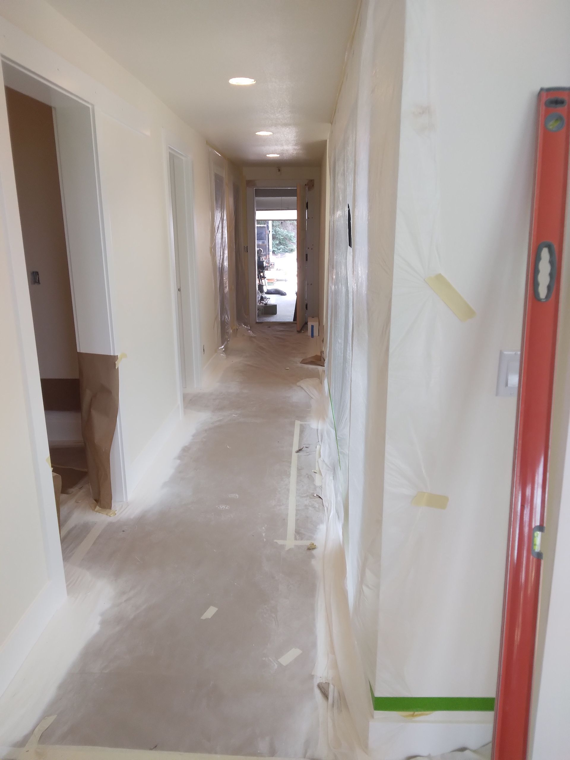 A long hallway with a red level on the side of it.