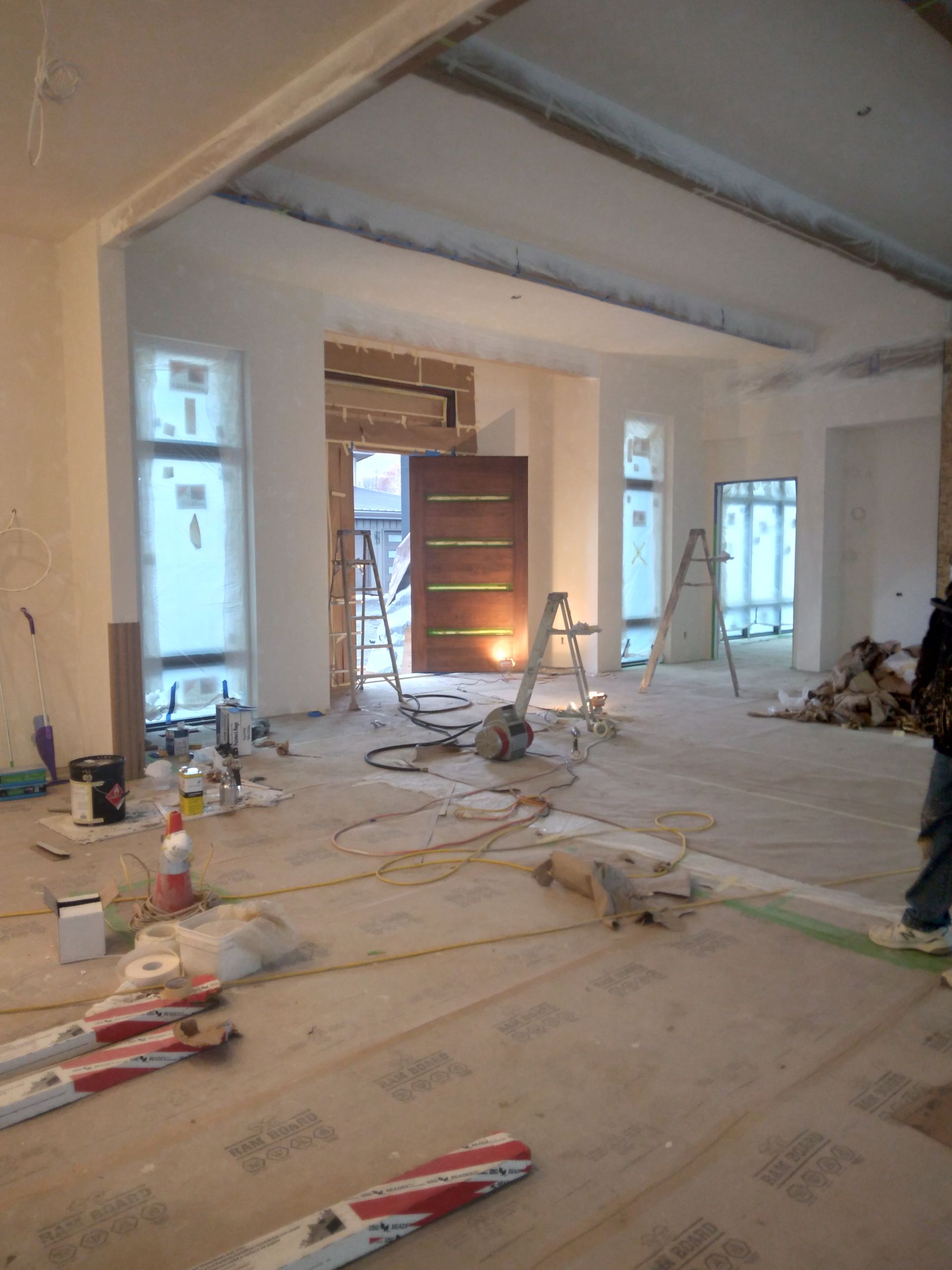 A large room is being remodeled with a lot of tools on the floor.