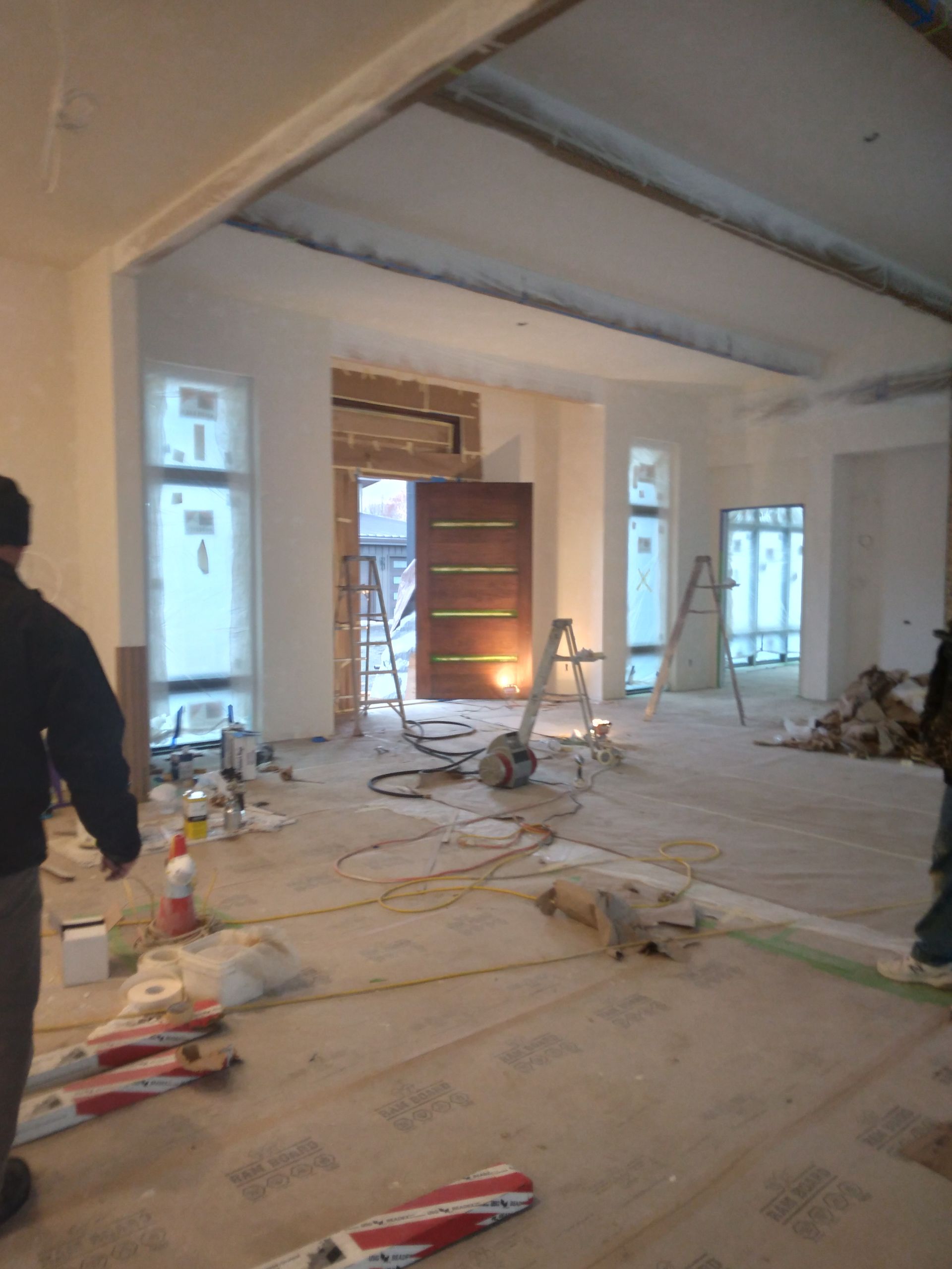 A man is standing in a room that is being remodeled.