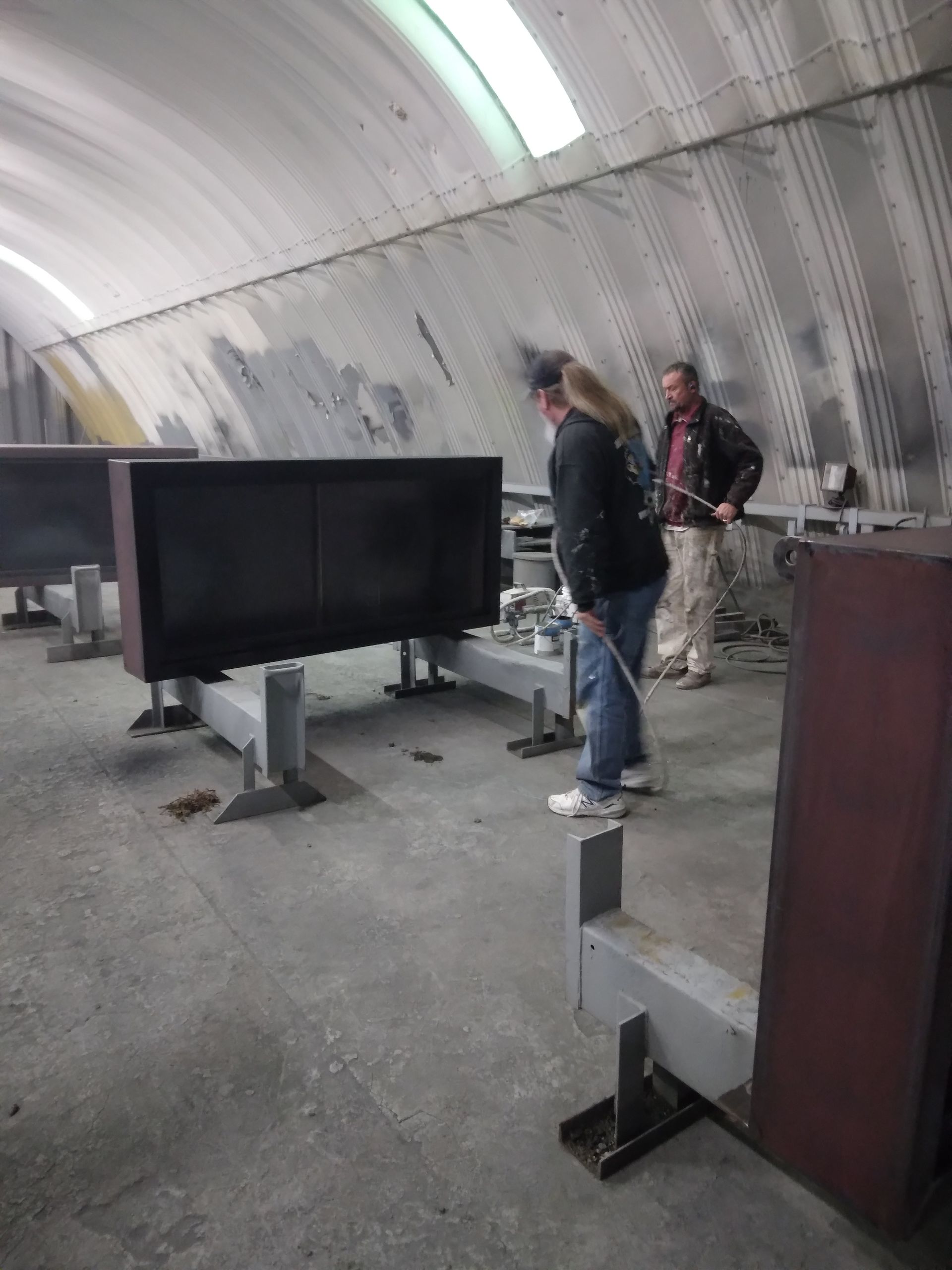 A man and a woman are standing in a room with a lot of boxes