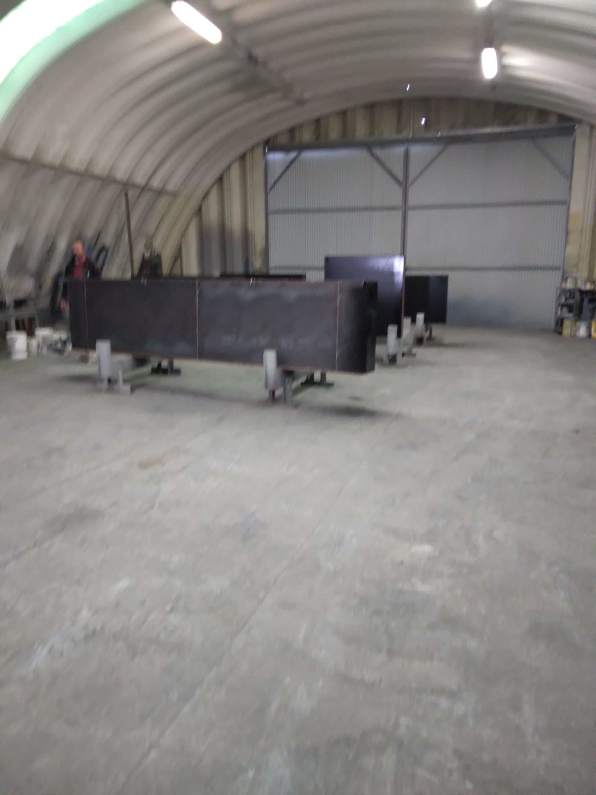 A large warehouse with a concrete floor and a ceiling