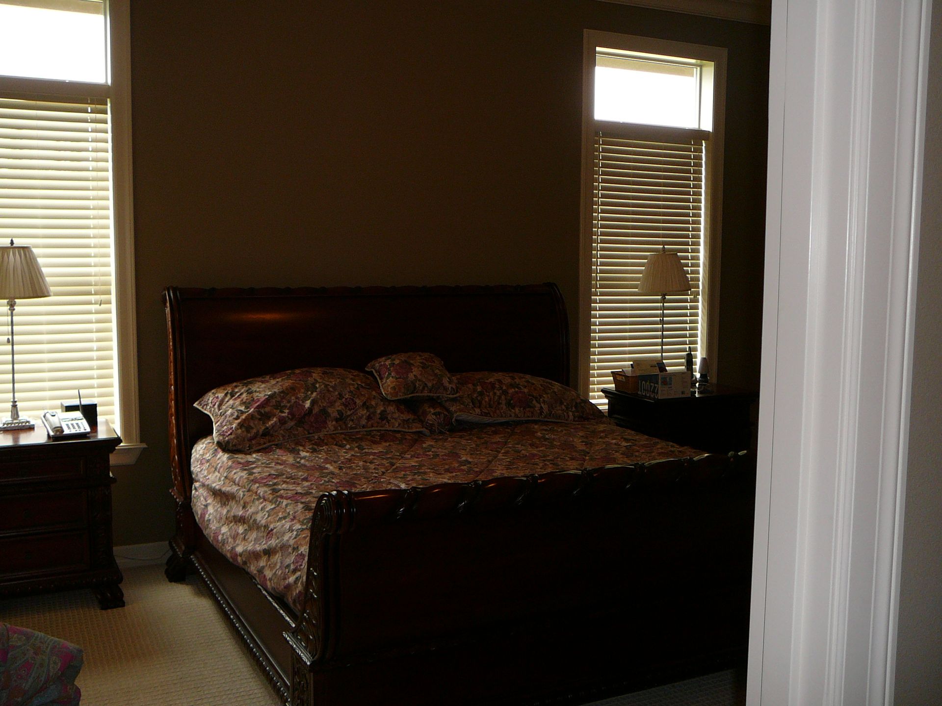 A bedroom with a large bed and two windows