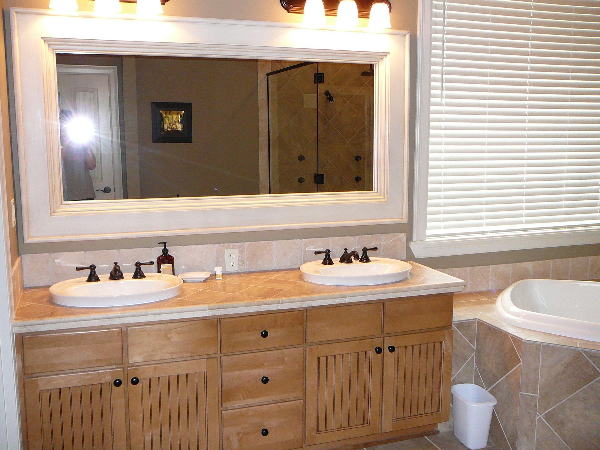 A bathroom with two sinks and a large mirror