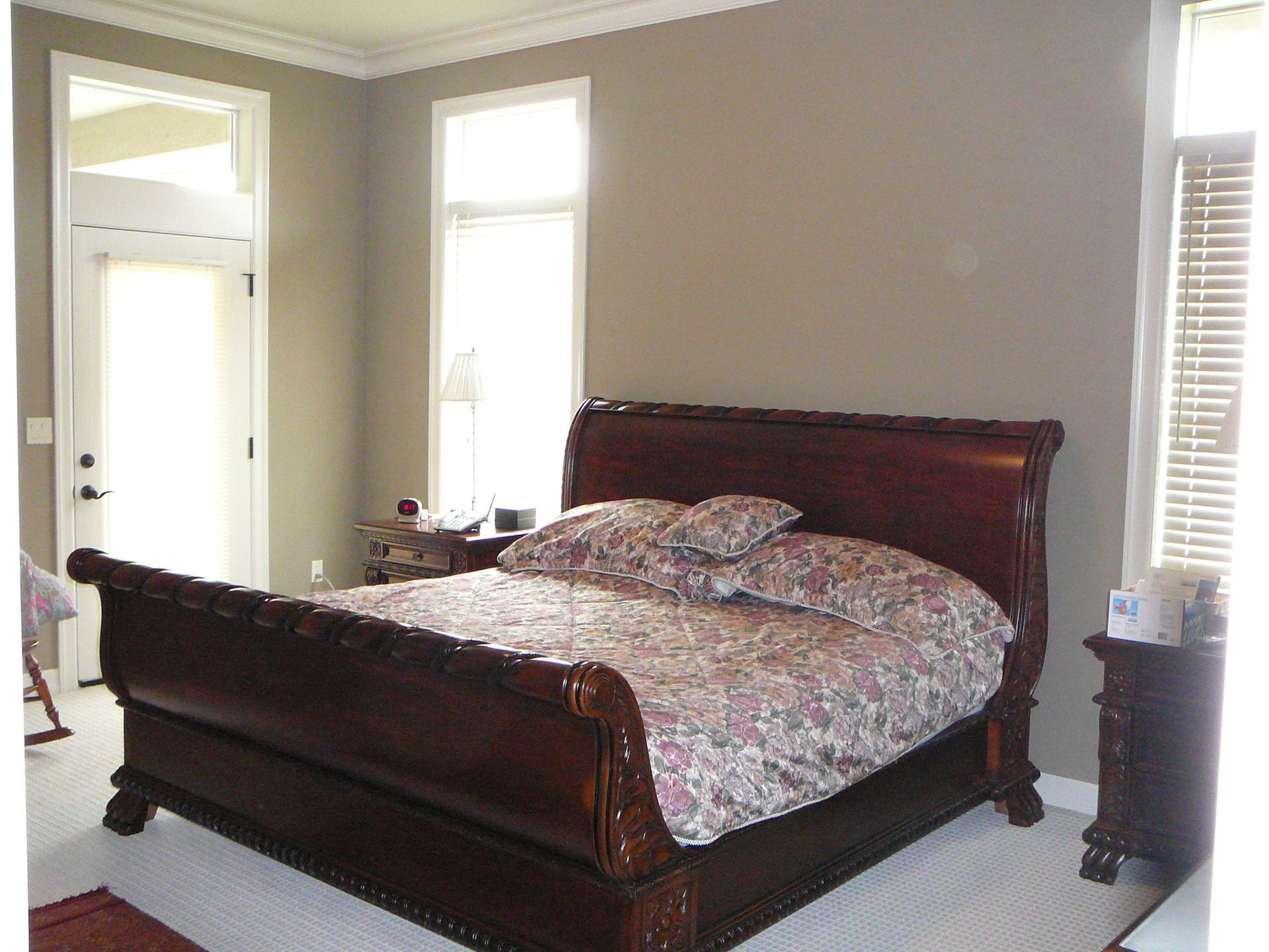 A bedroom with a sleigh bed and two windows
