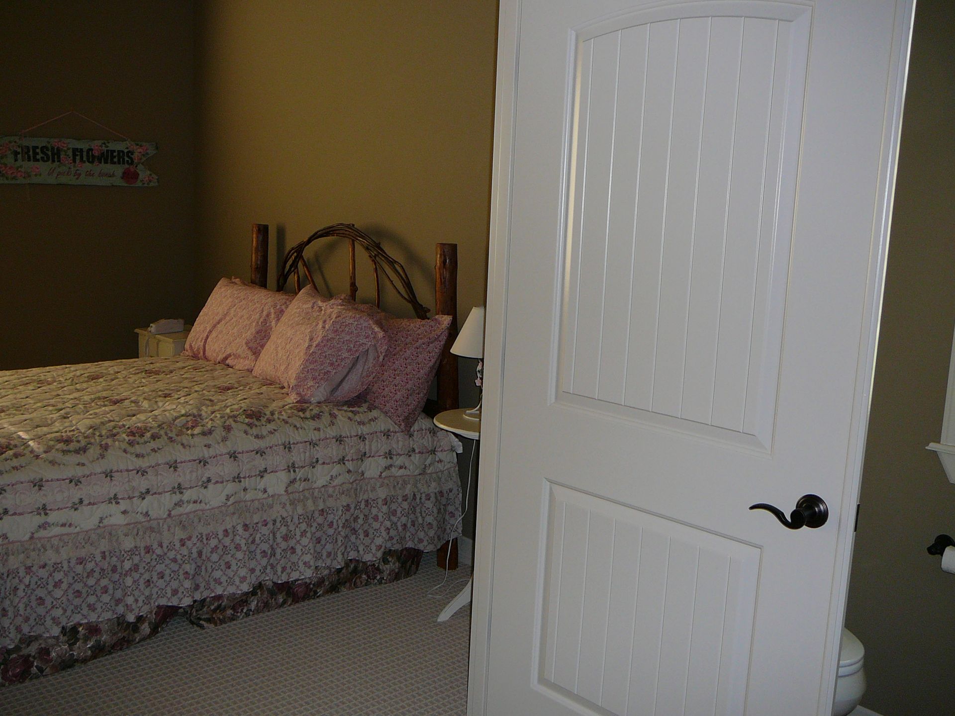 A bedroom with a bed and a white door