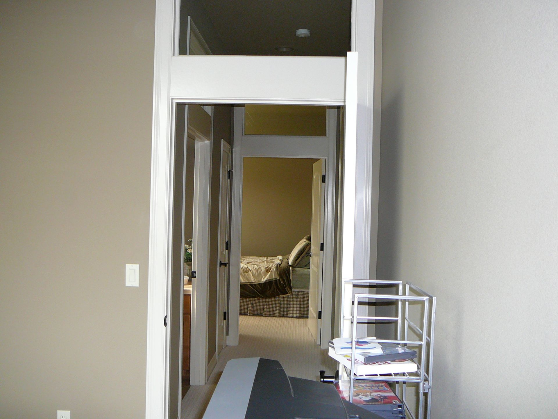 A hallway in a house leading to a bedroom