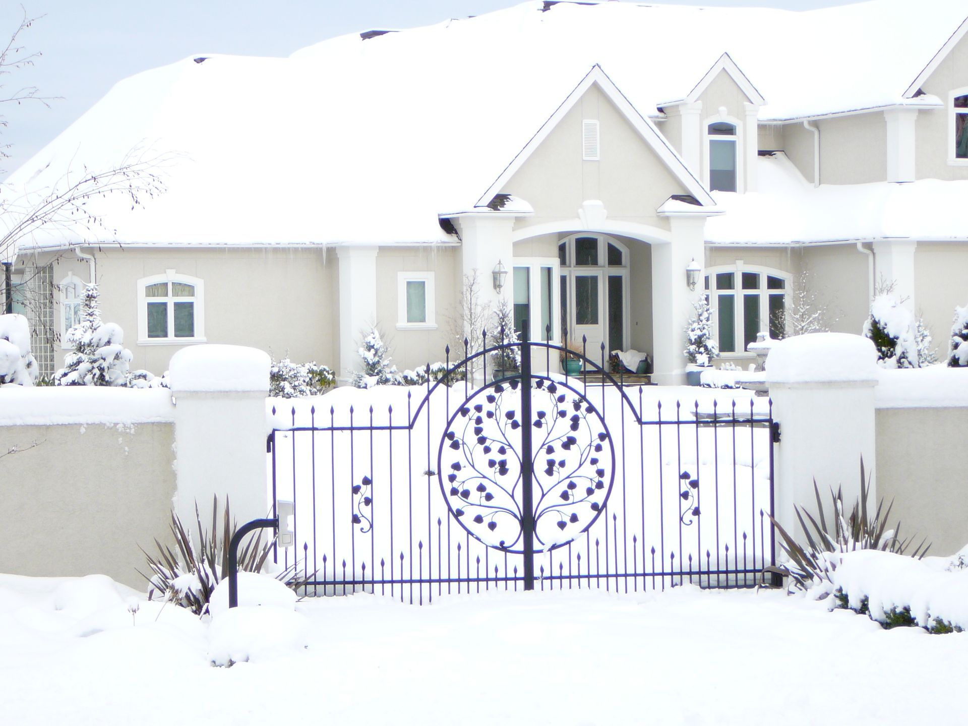 A snowy house with a gate in front of it