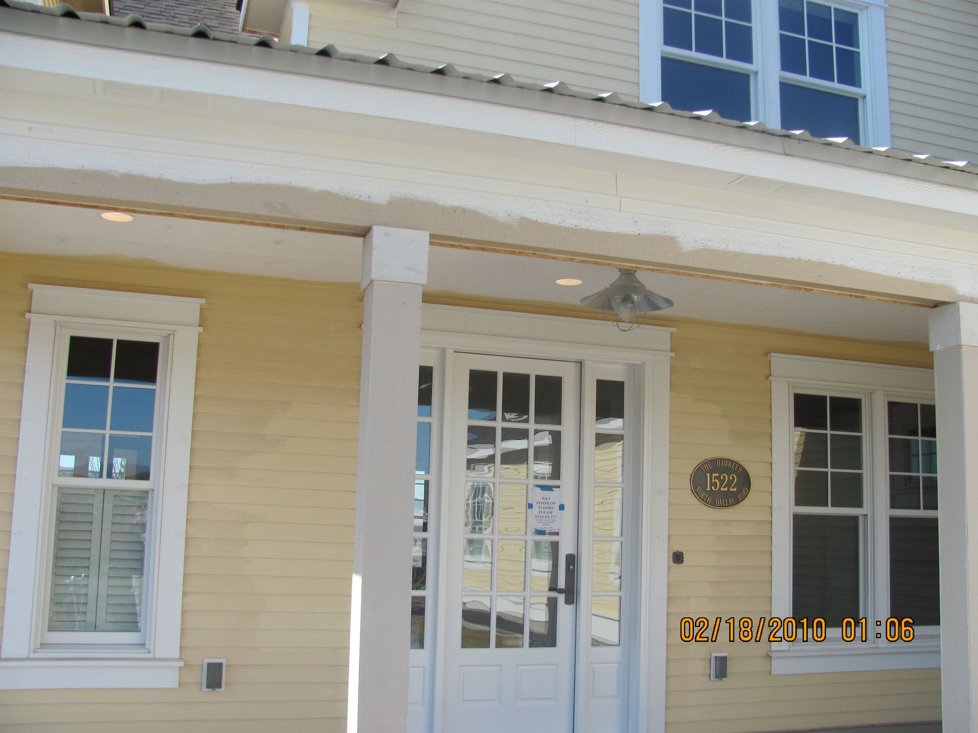 A yellow house with a white door and windows