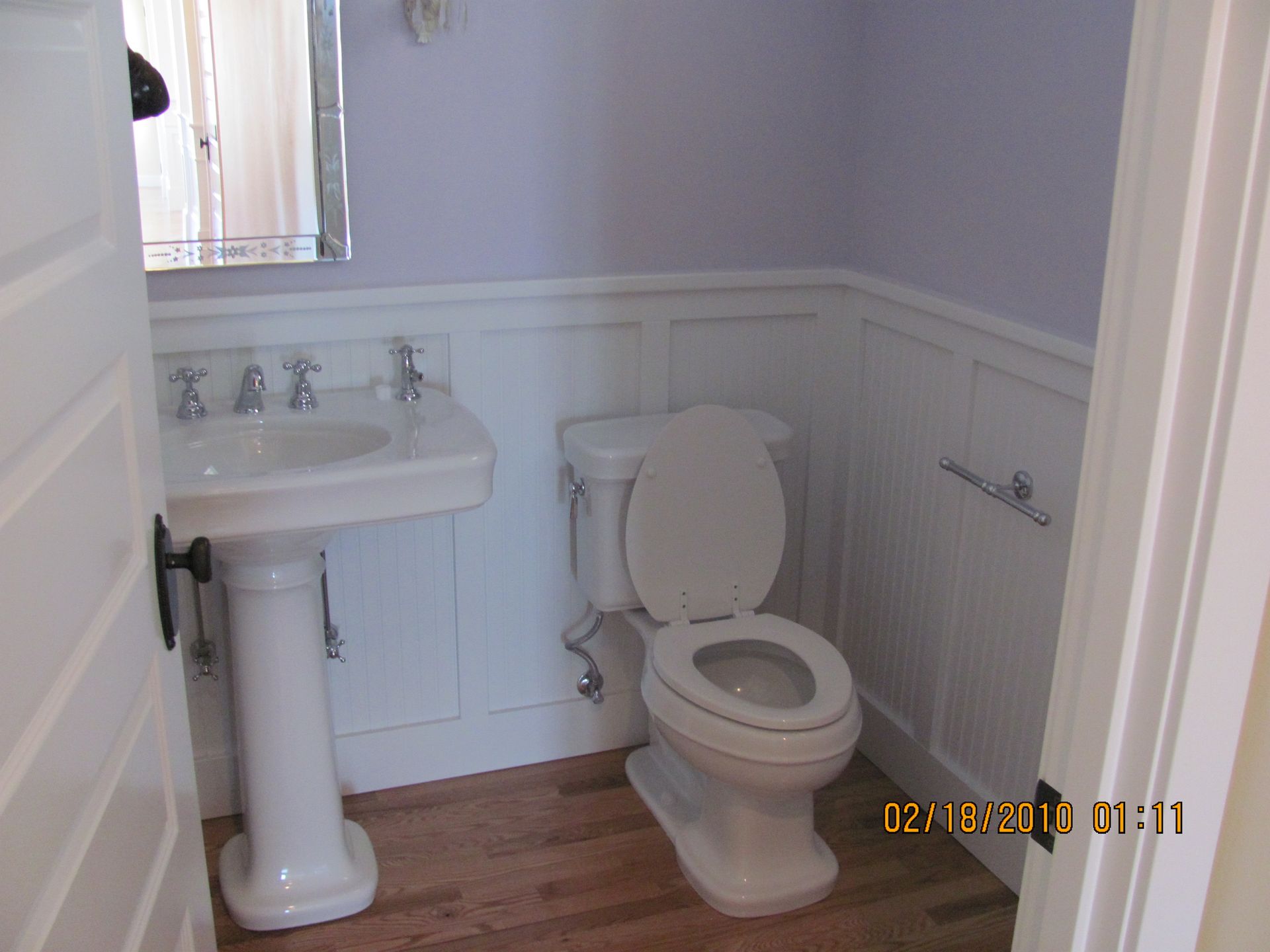 A bathroom with a toilet a sink and a mirror