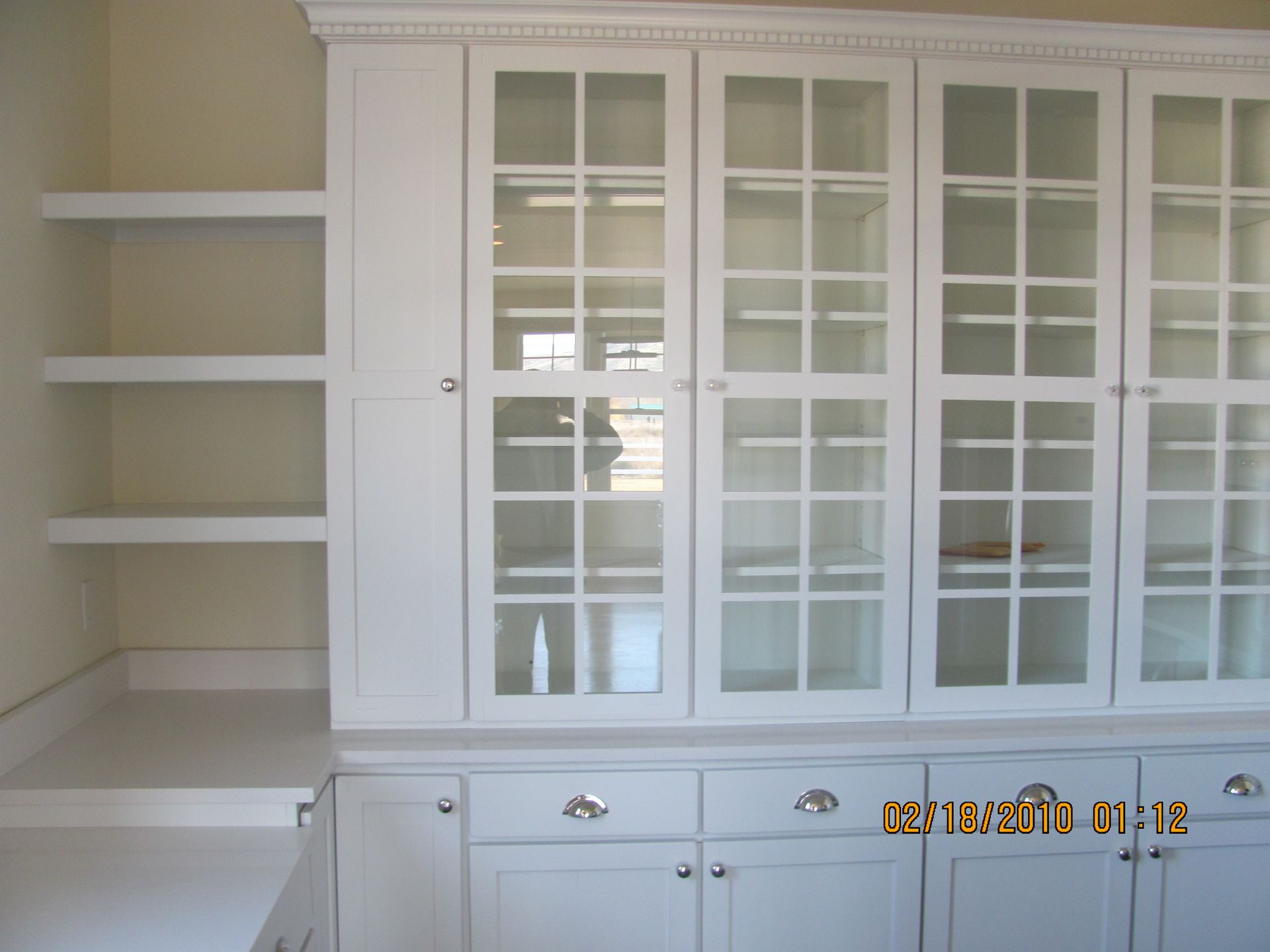 A picture of a cabinet with glass doors was taken on october 18 2010