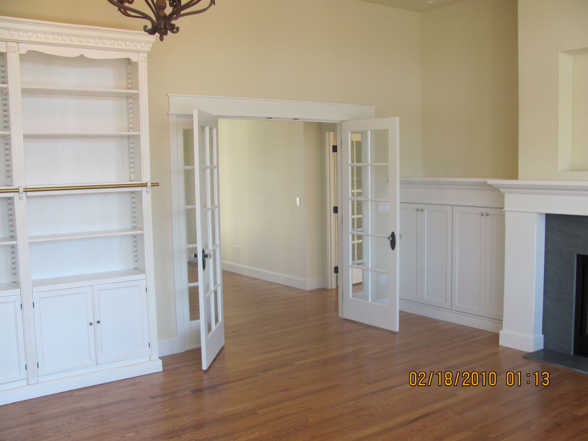 An empty living room with a fireplace and shelves