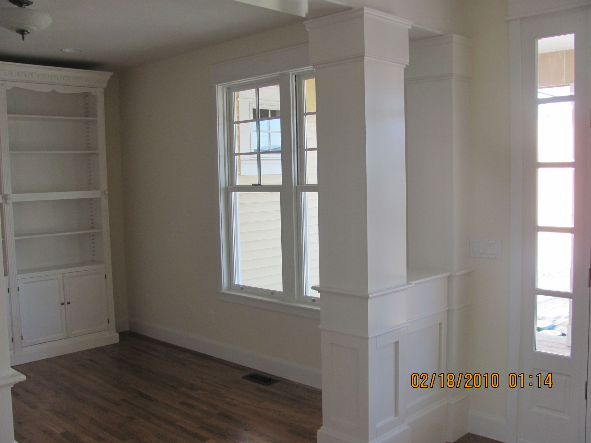 An empty room with a bookcase and a window taken on february 28 2013
