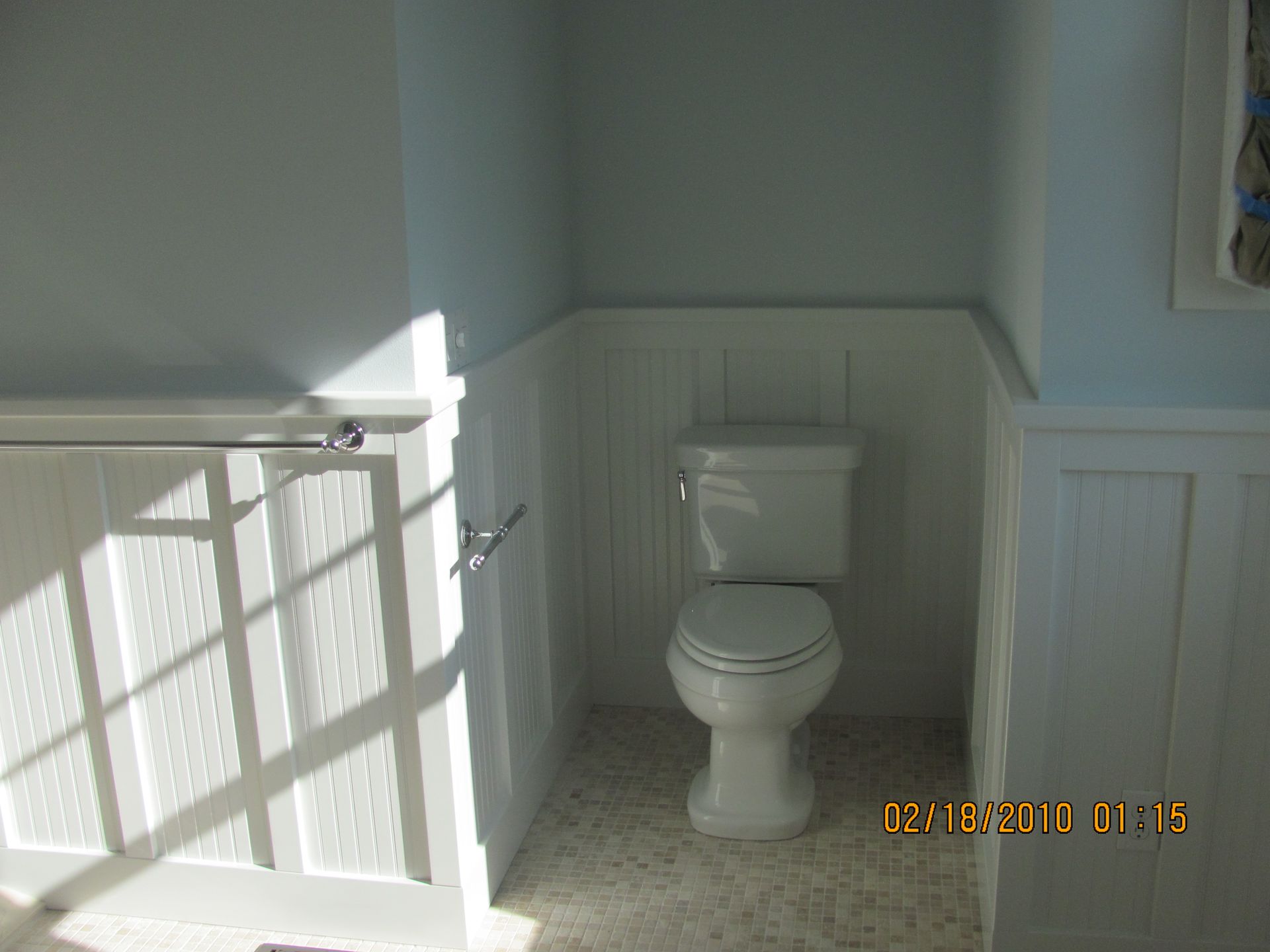 A bathroom with a toilet and a picture taken on february 18 2010