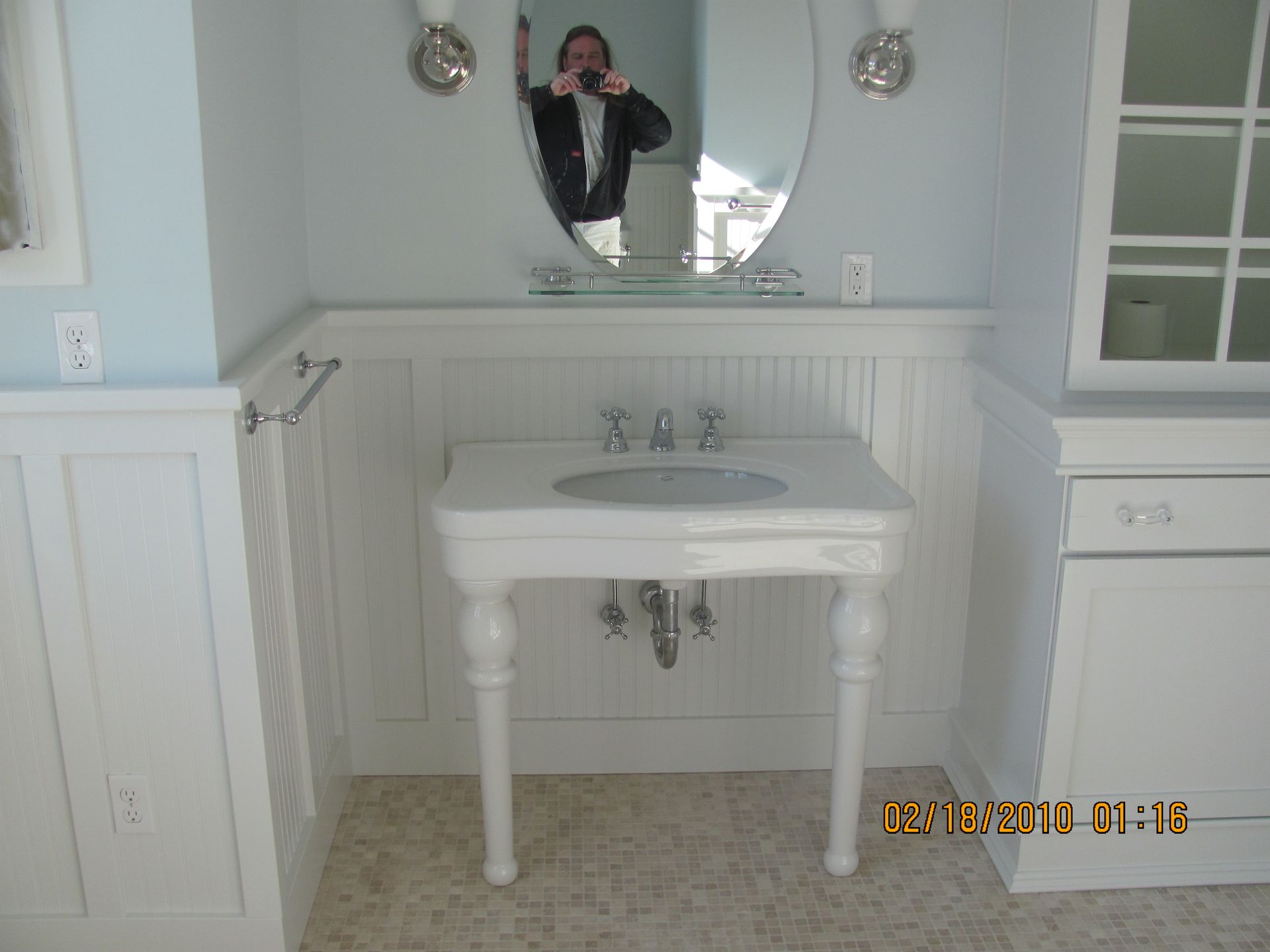 A man taking a picture of himself in a bathroom sink