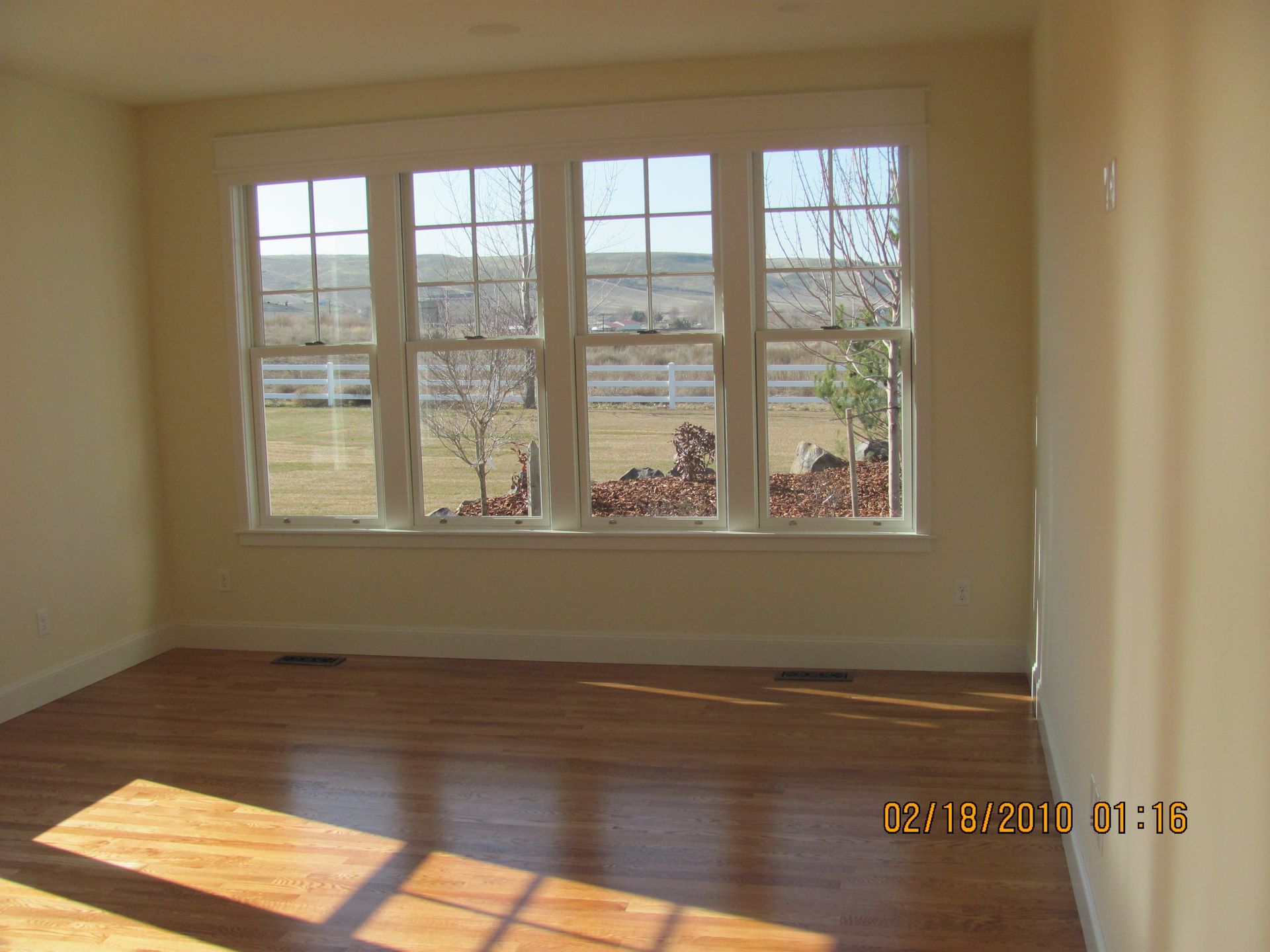 An empty room with hardwood floors and a picture taken on february 18 2010