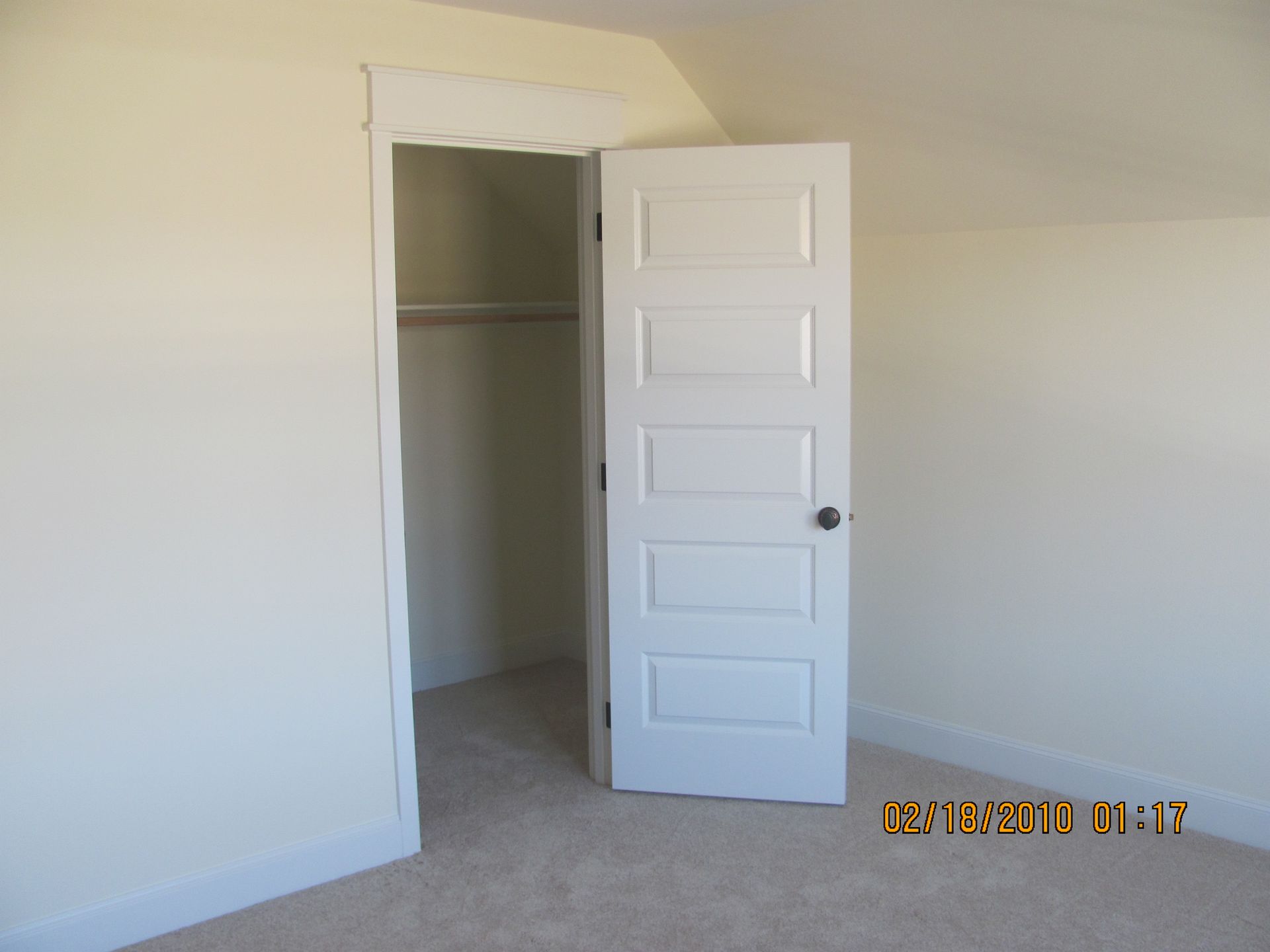 An empty room with a white door and a photo taken on 08/30/2018