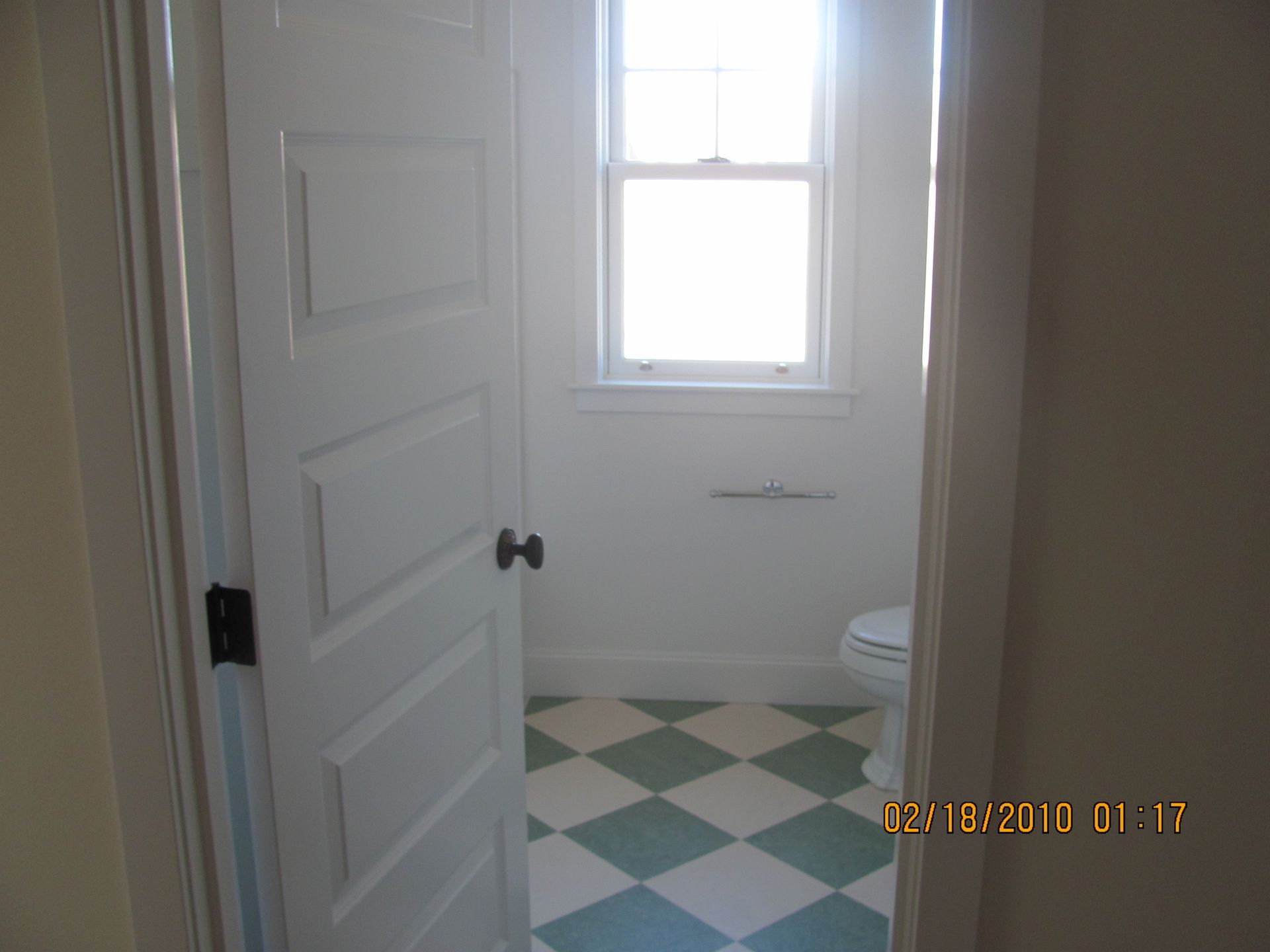 A bathroom with a checkered floor and a window