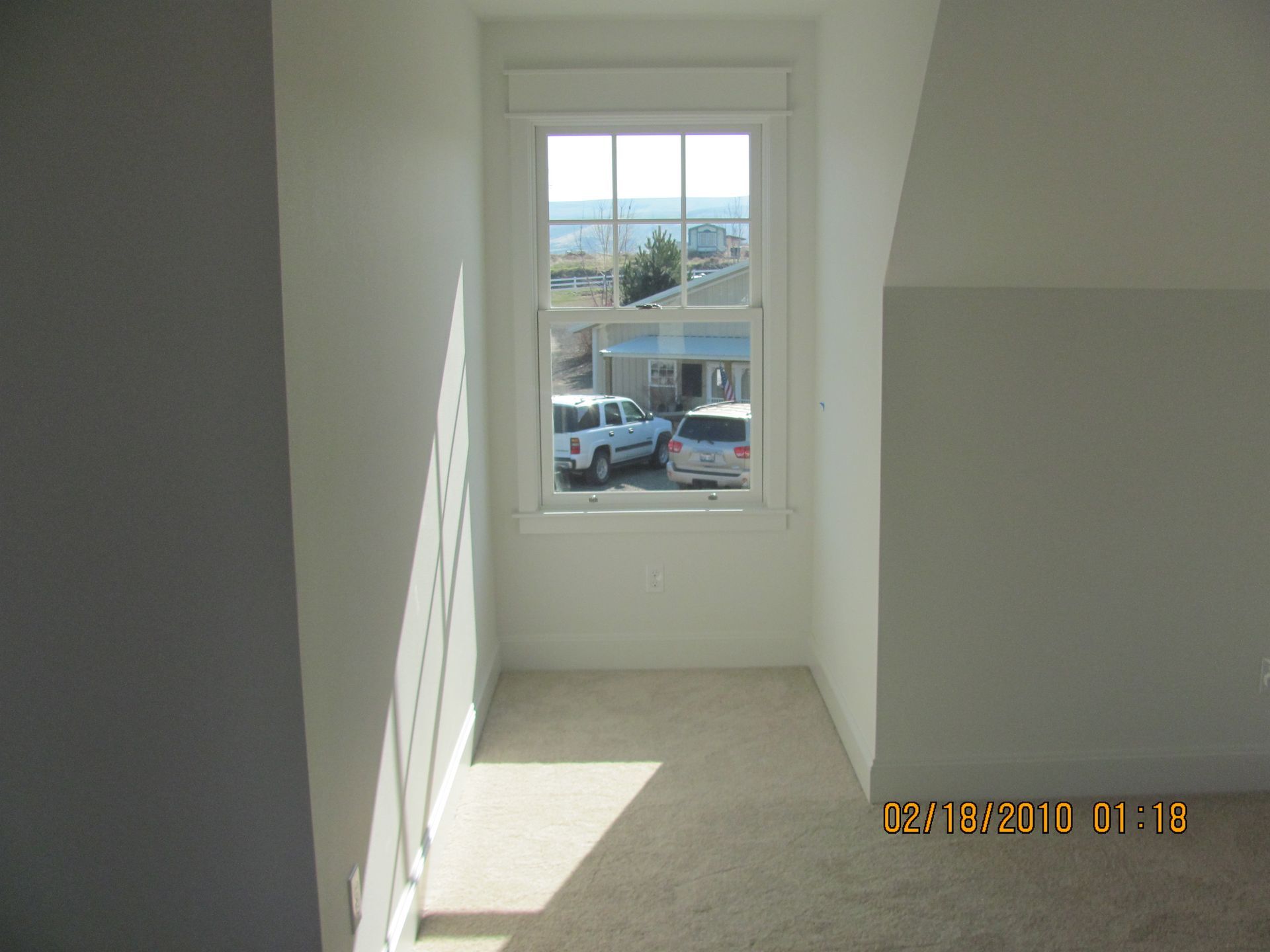 An empty room with a window and a picture taken on oct 8 2010