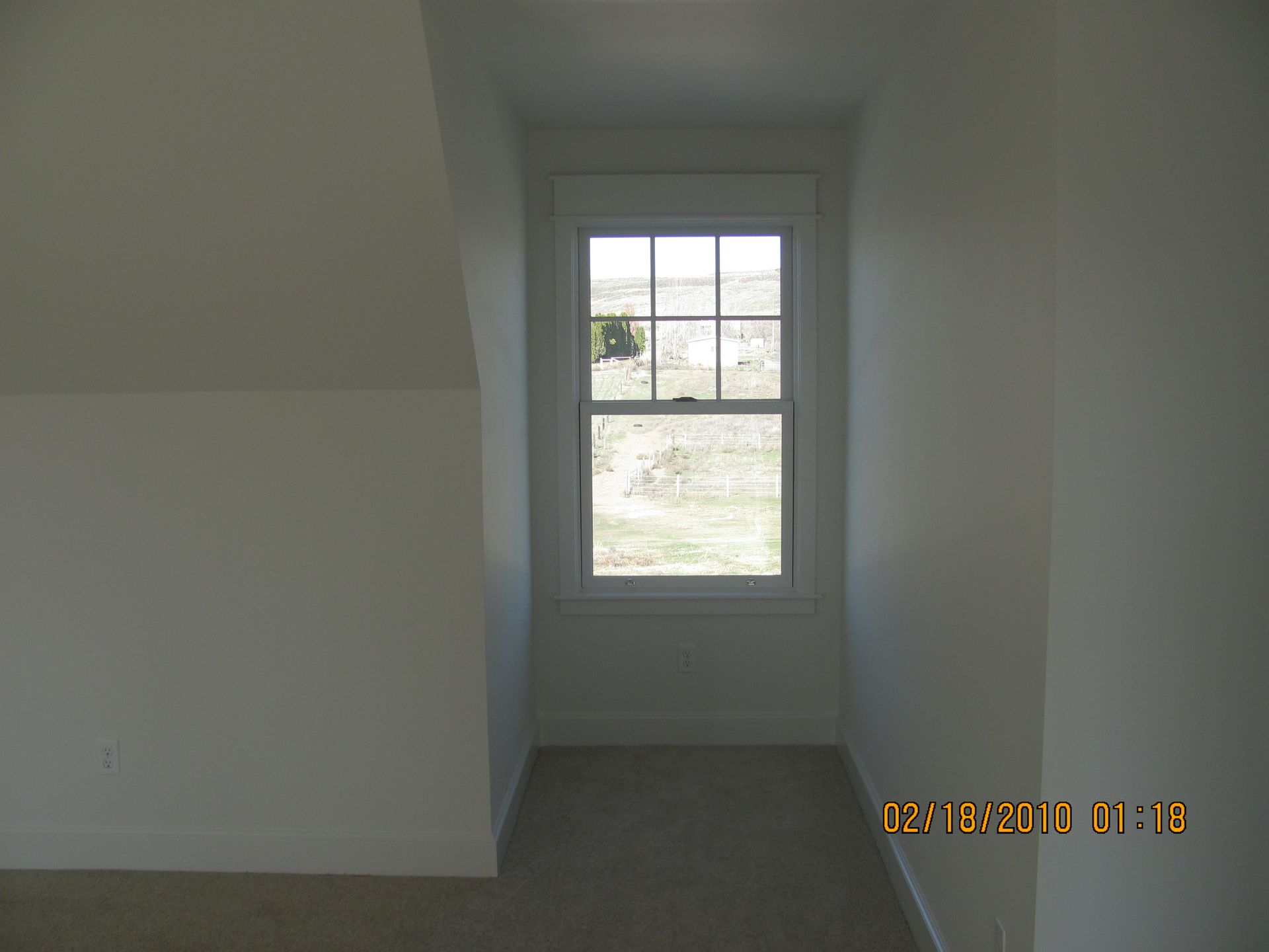 A picture of an empty room with a window taken on october 8th 2013