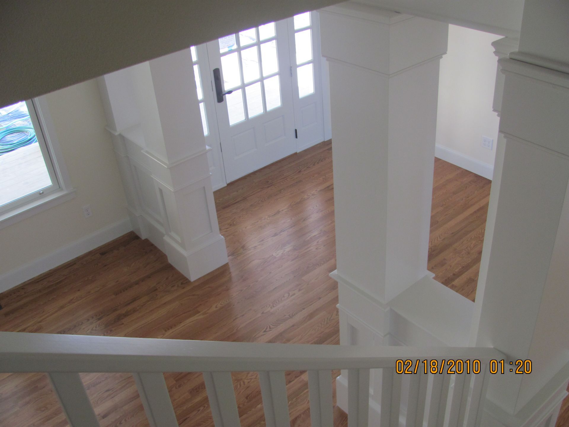An aerial view of a house with wood floors and white pillars