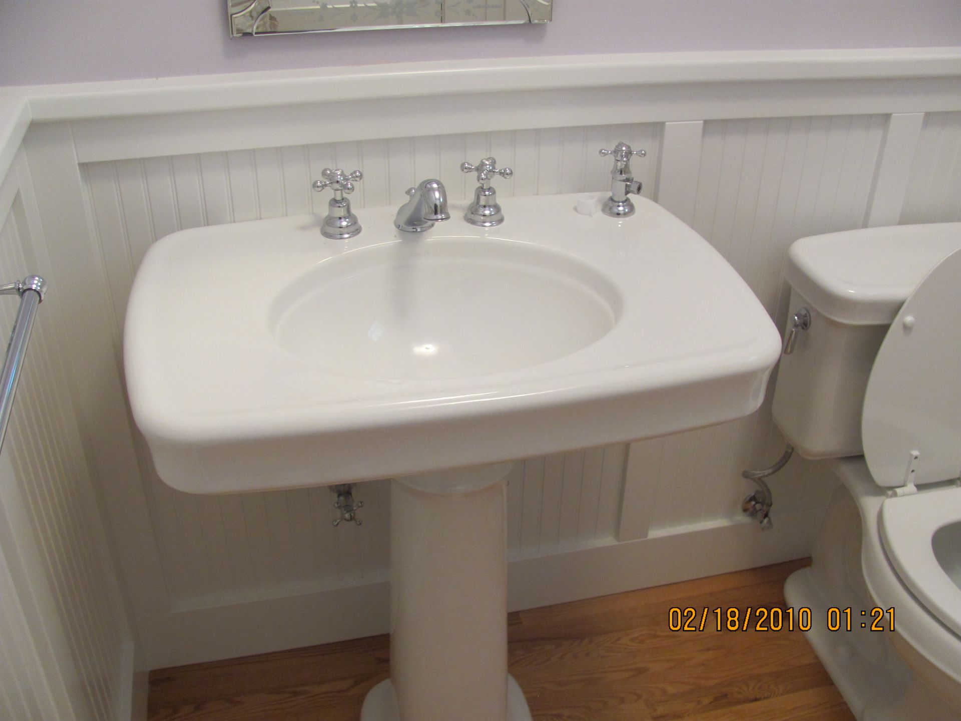 A bathroom with a pedestal sink and a toilet