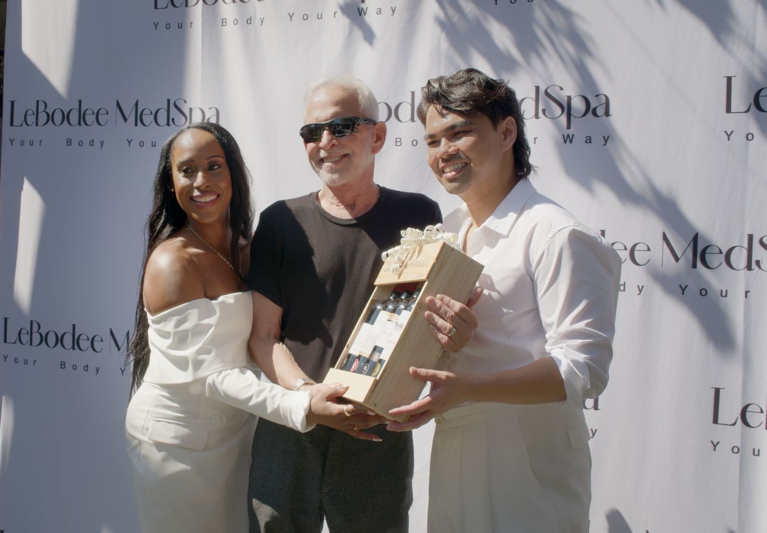 A group of people standing in front of a sign that says le bodee med spa