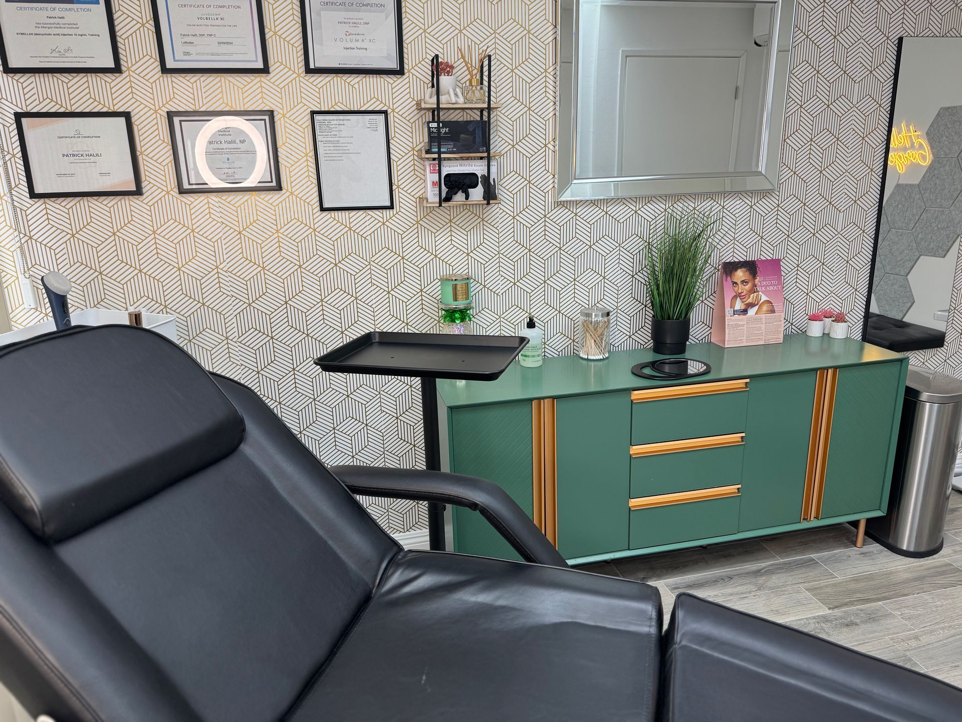 A black chair is sitting in a room next to a green cabinet.