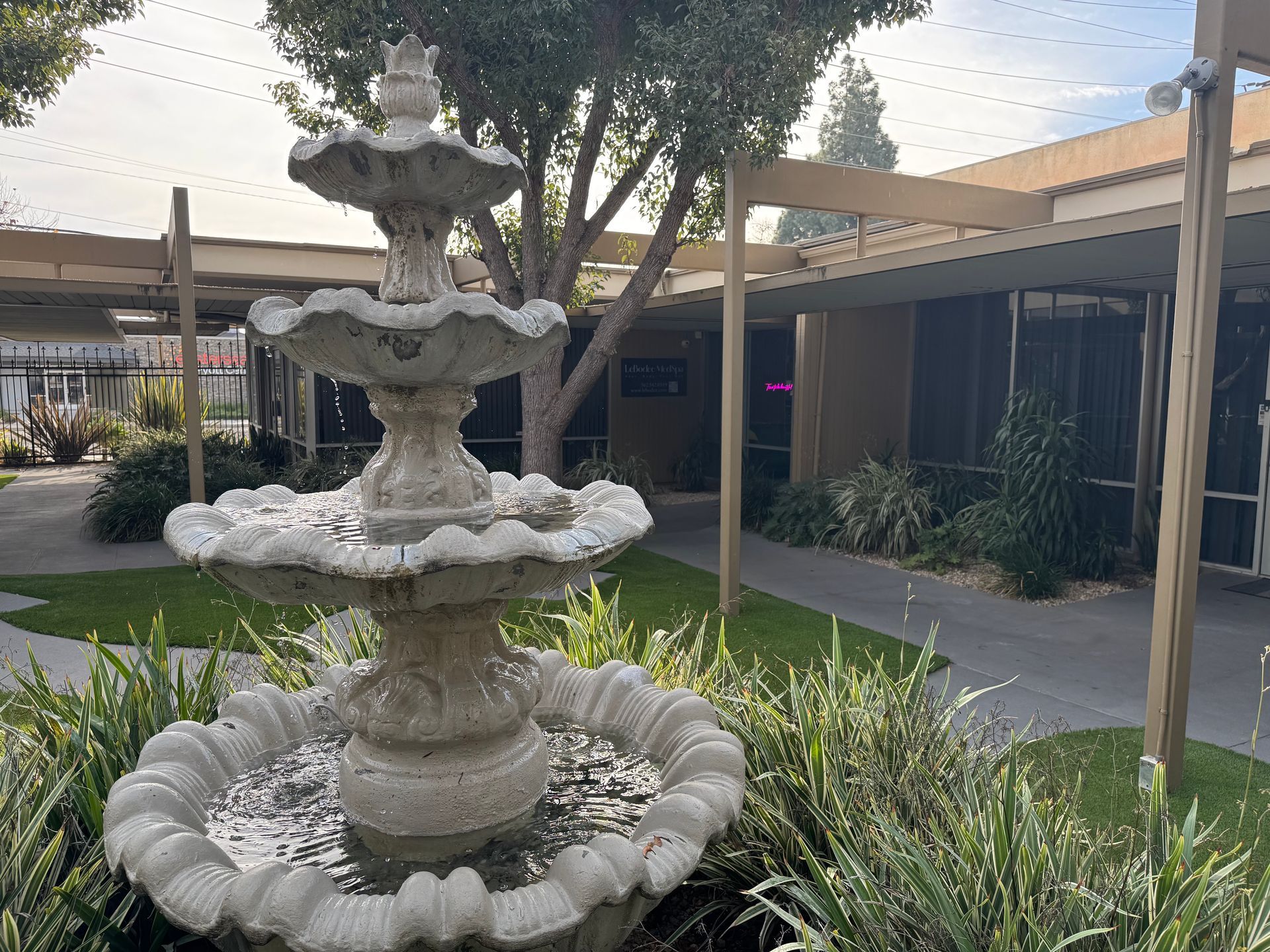 A waiting room with a green couch and a lion painting on the wall.